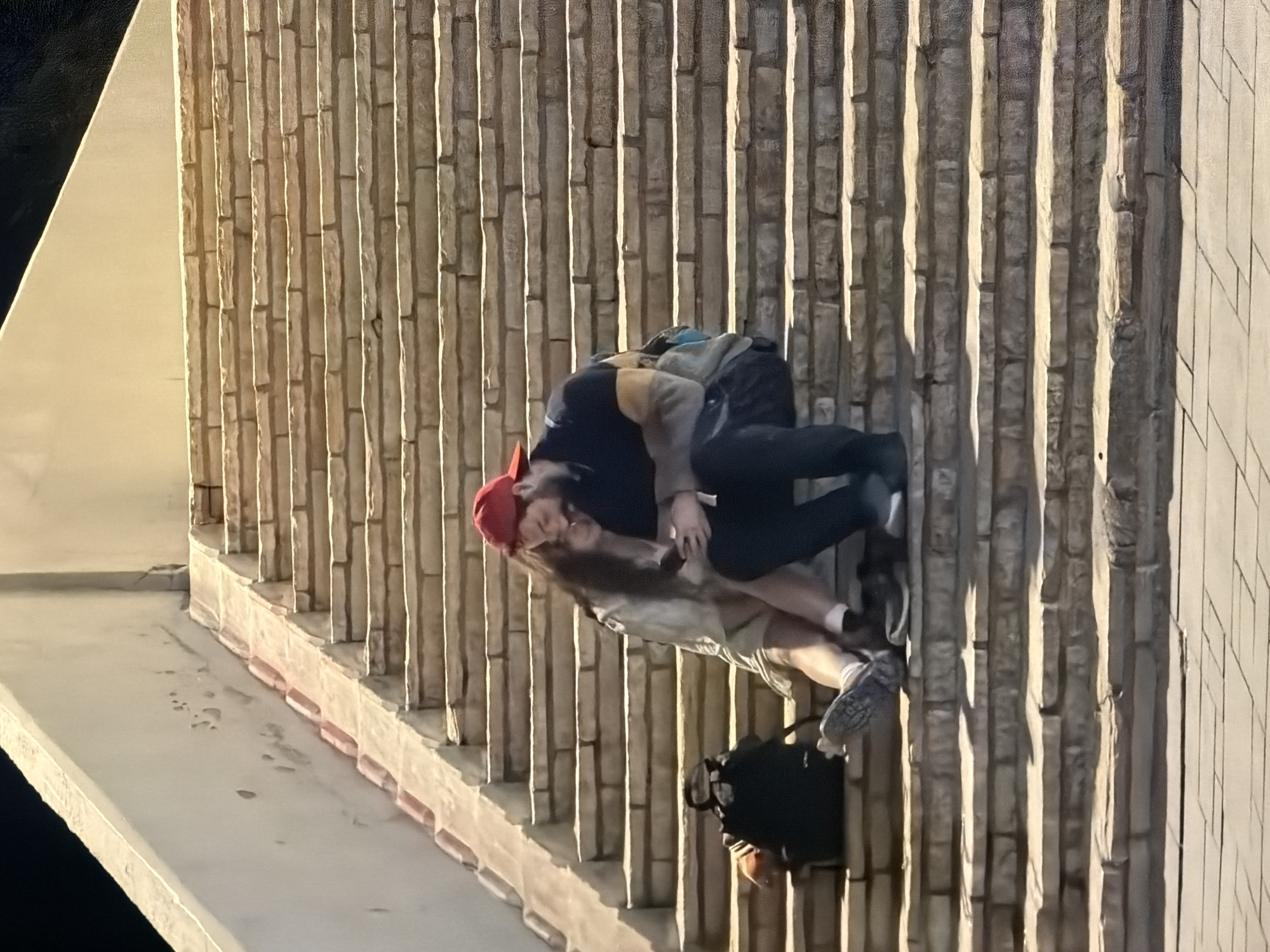 Two people embrace beside wall in Tel Aviv