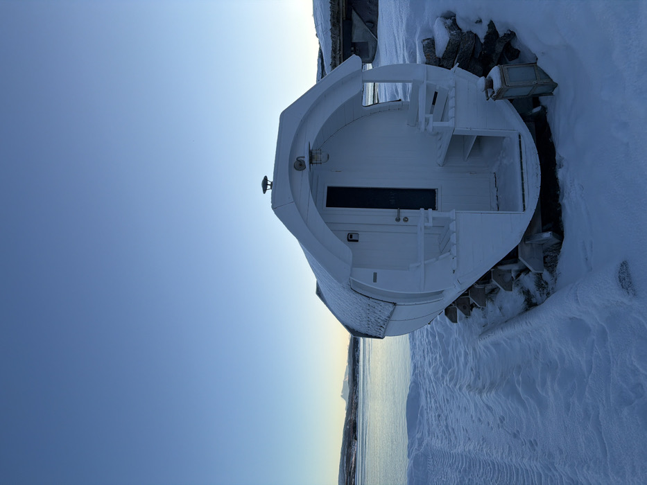 White barrel sauna spotted on snowy waterfront in Harstad
