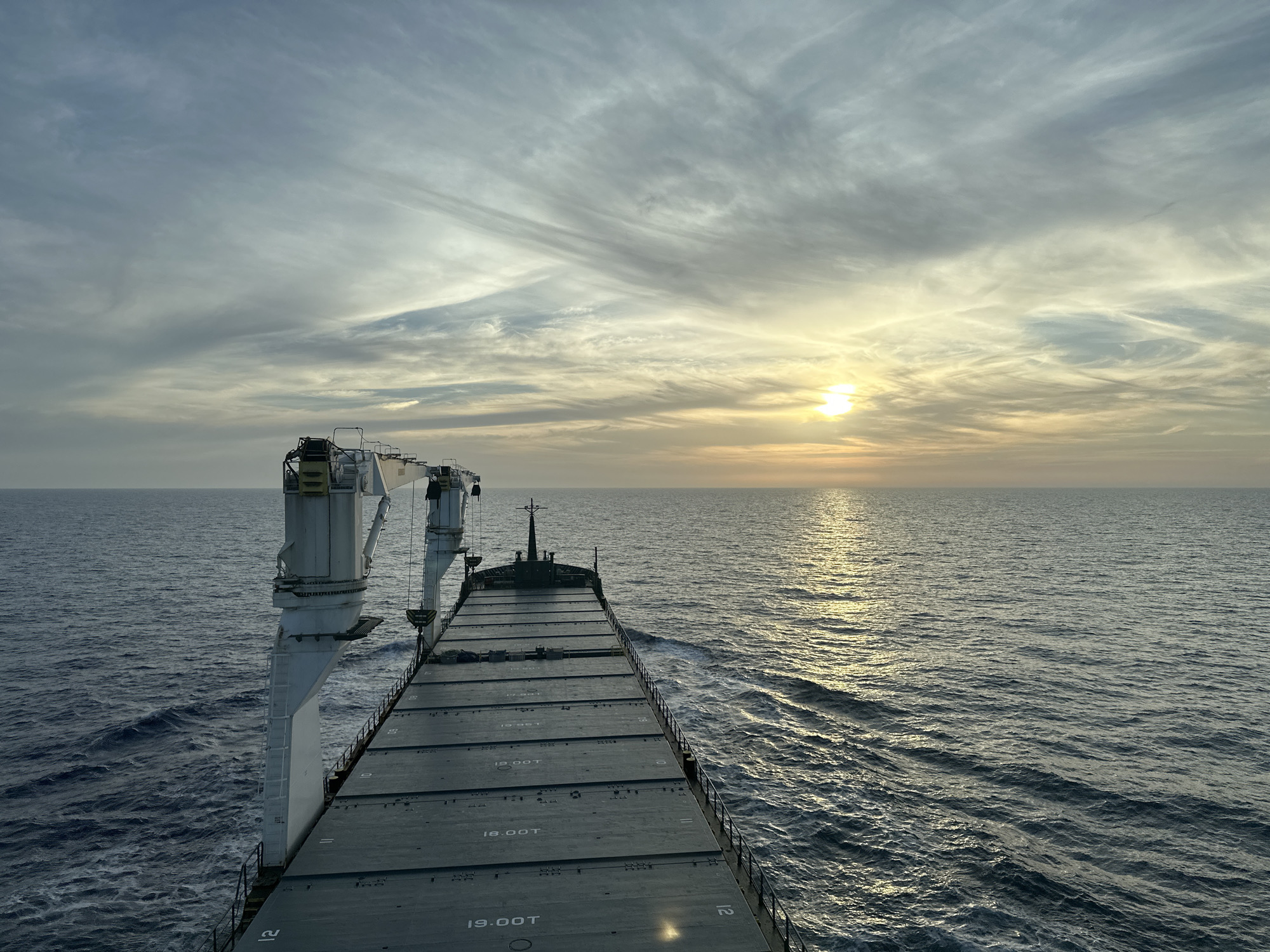 Cargo ship observed sailing Mediterranean waters at sunset