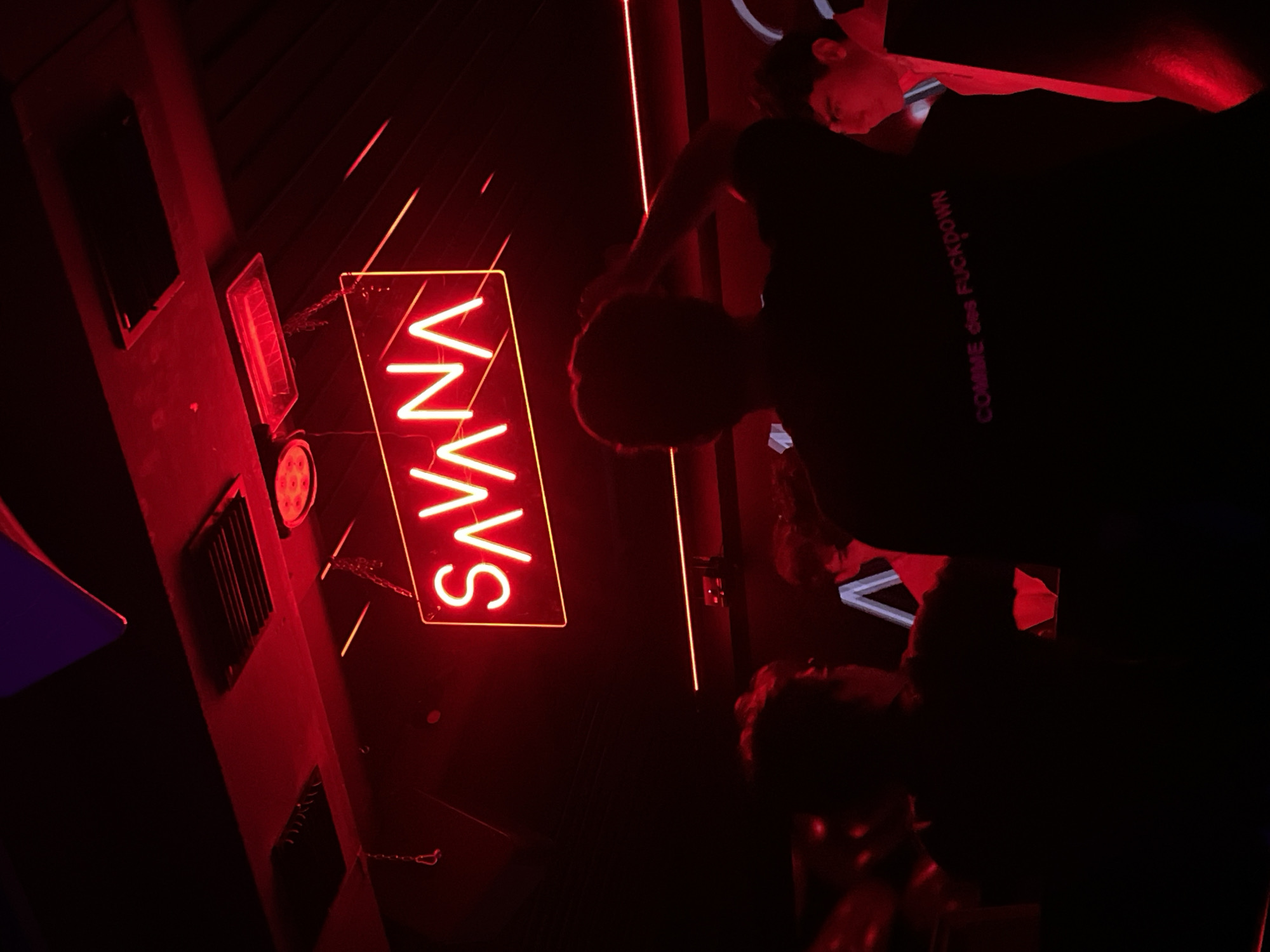 Nightclub scene captured in Milan featuring neon signage
