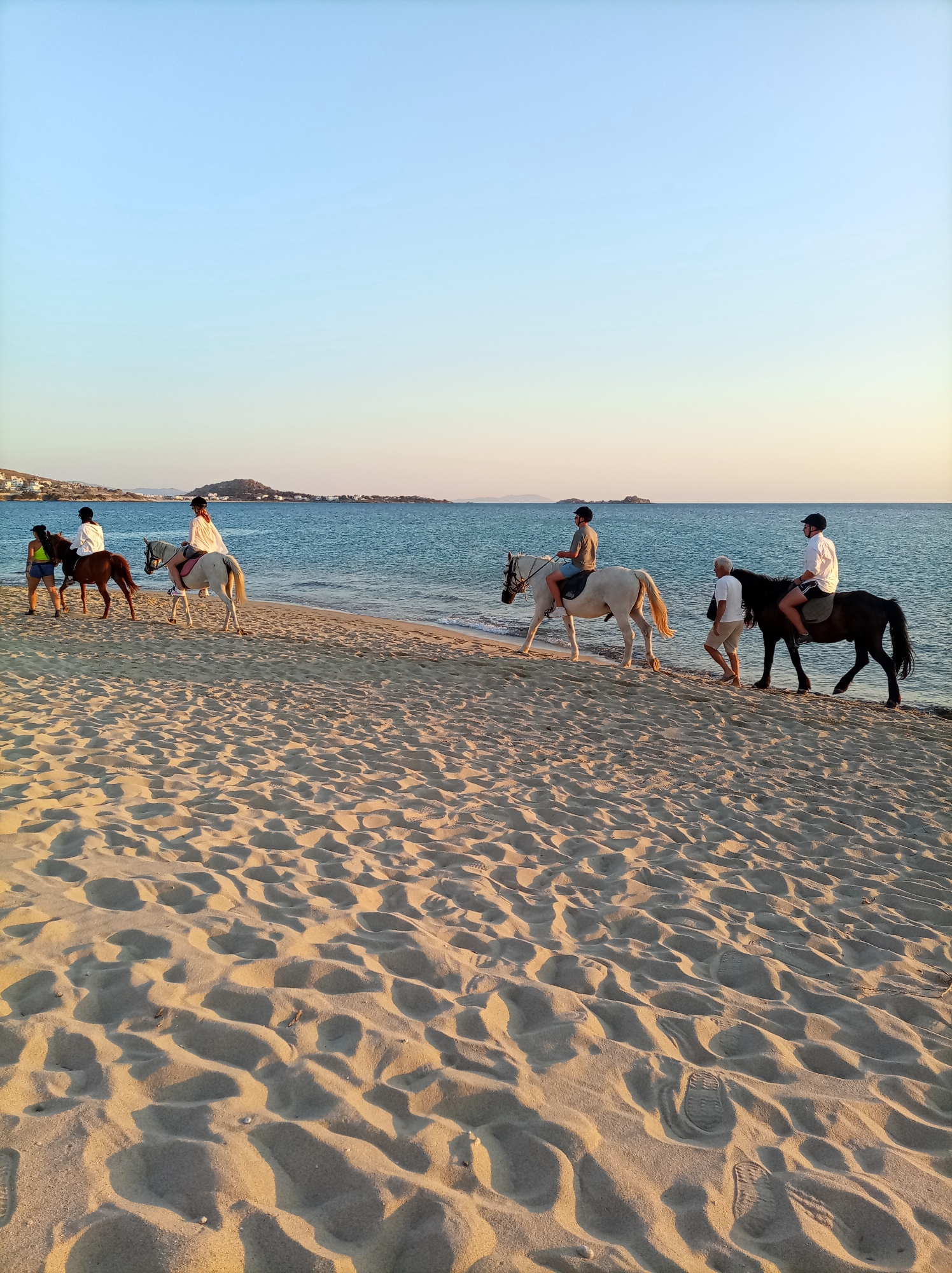 Sunny afternoon at a calm coastal beach, sunset included.