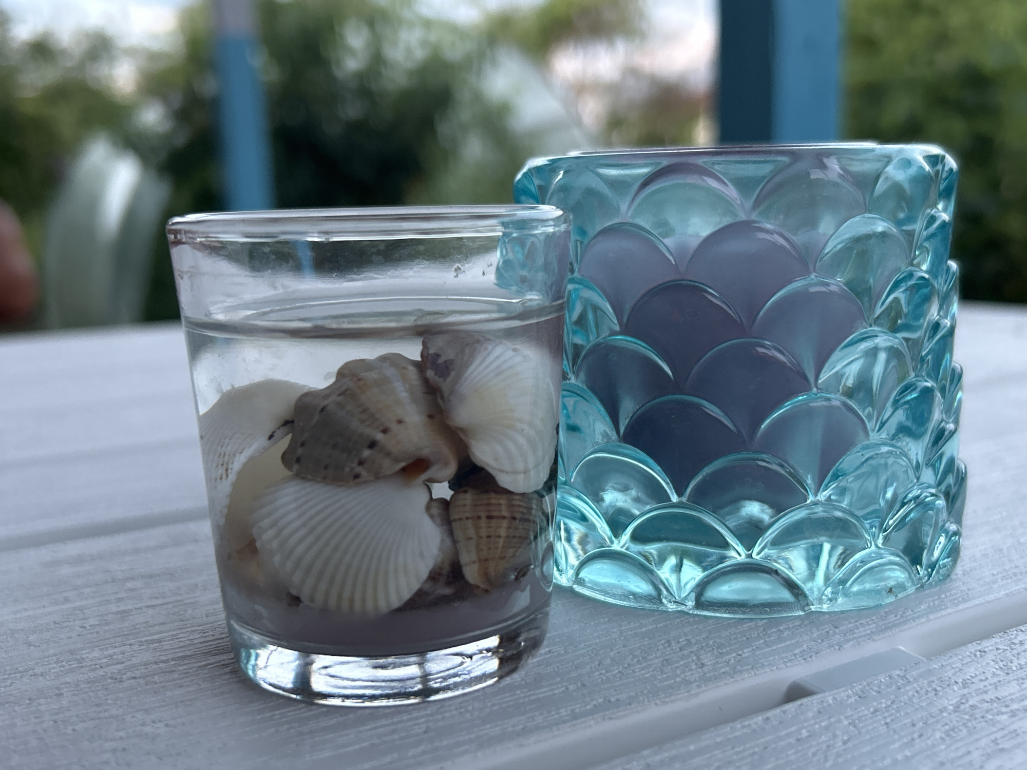Coastal-themed glass décor on a white wooden surface