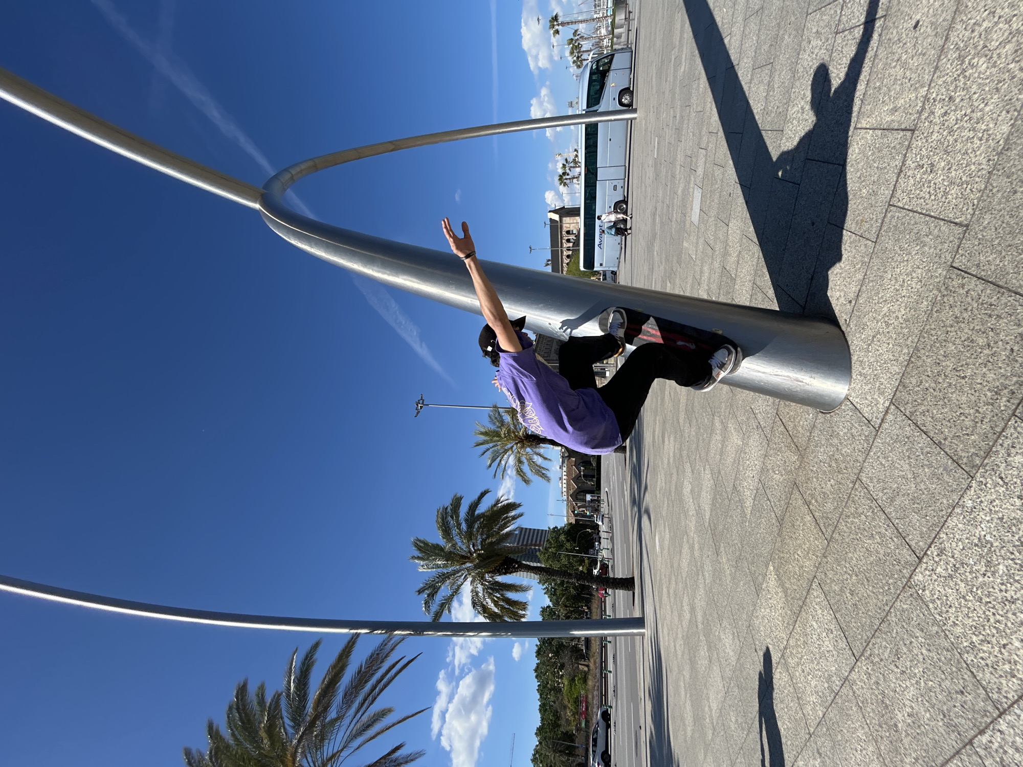 Skateboarder performs tricks in Barcelona plaza on sunny afternoon