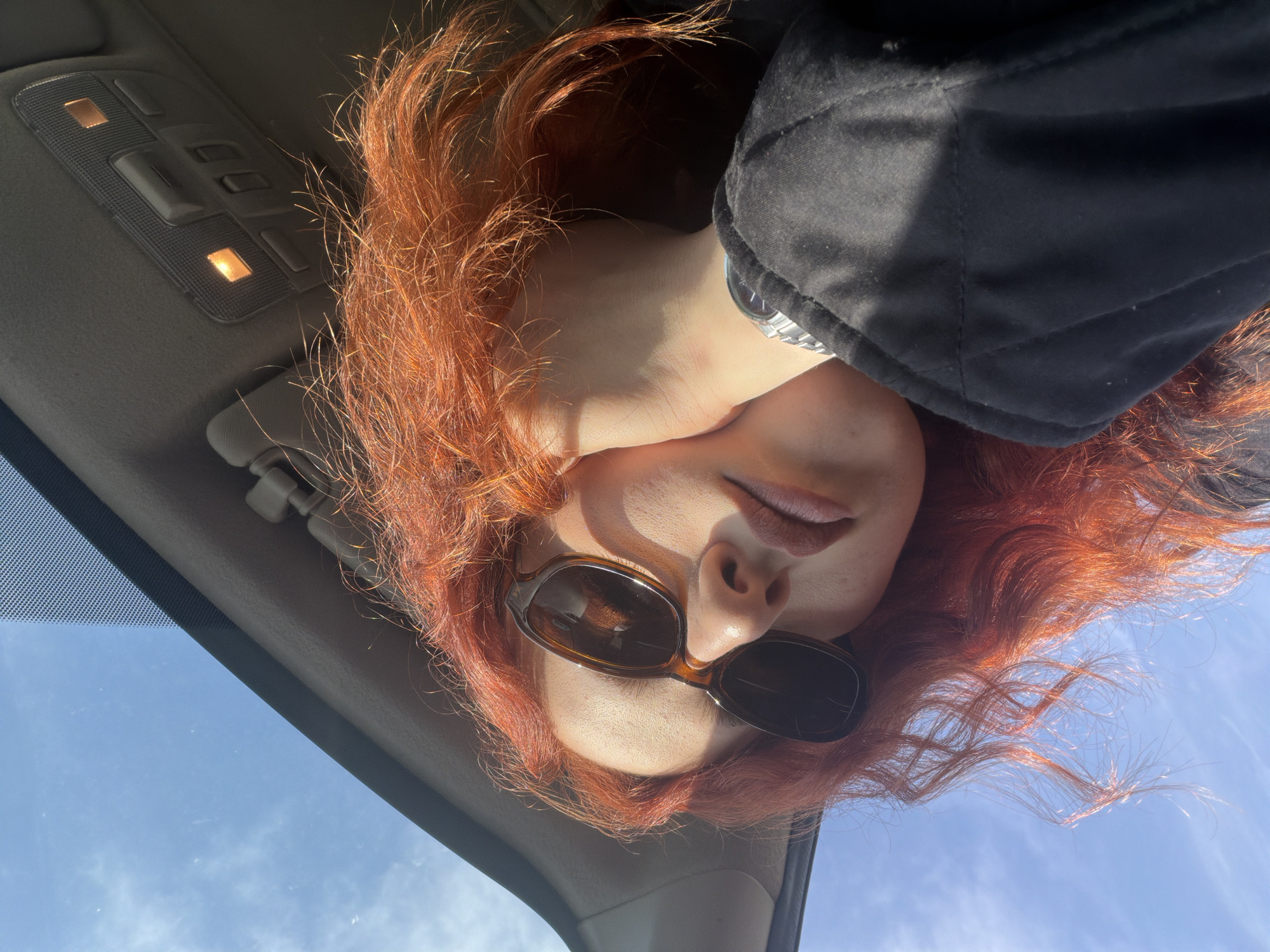 Person with red hair photographed inside car in Tbilisi