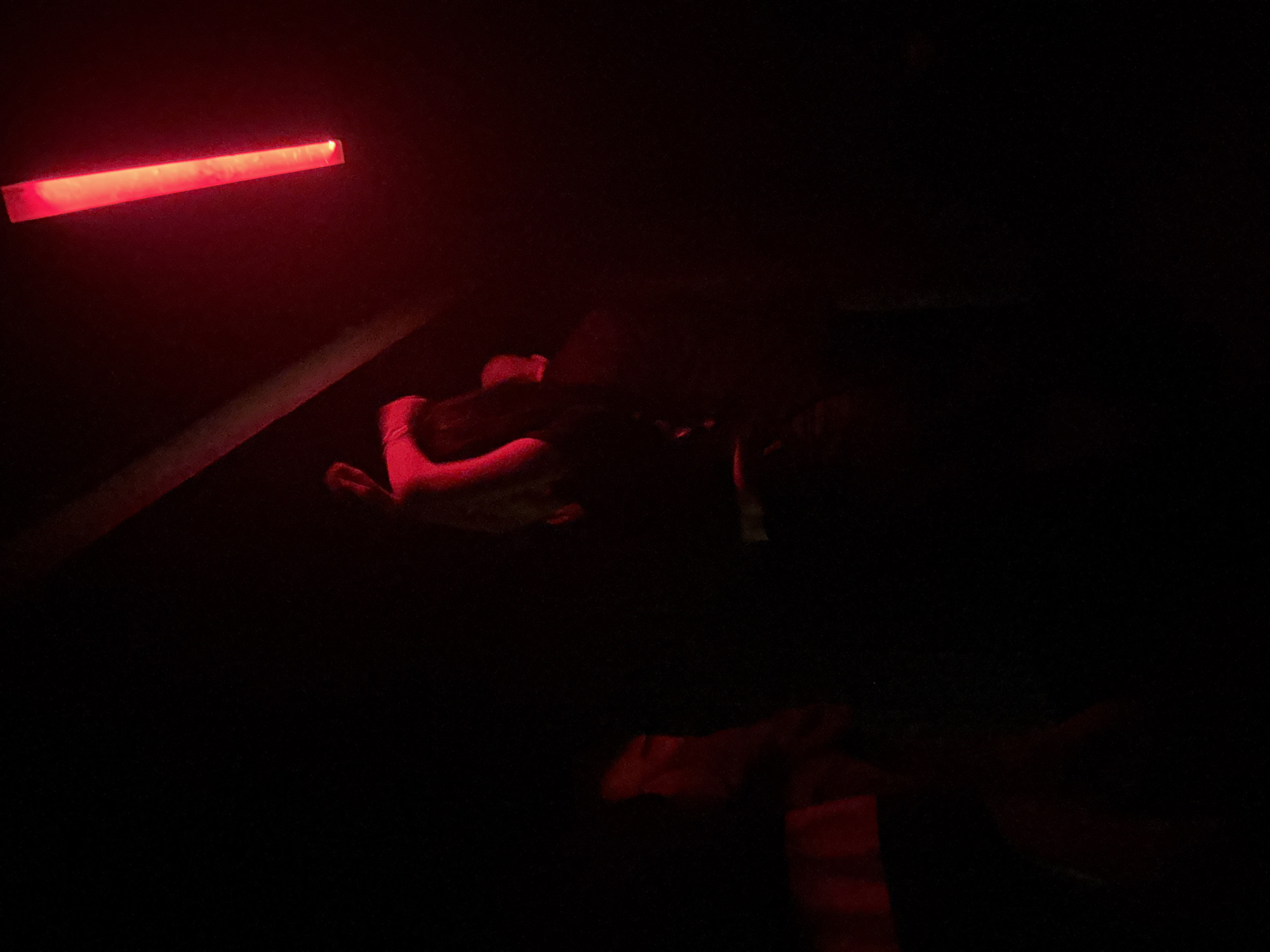 Nighttime gathering captured in red-lit venue in Tbilisi
