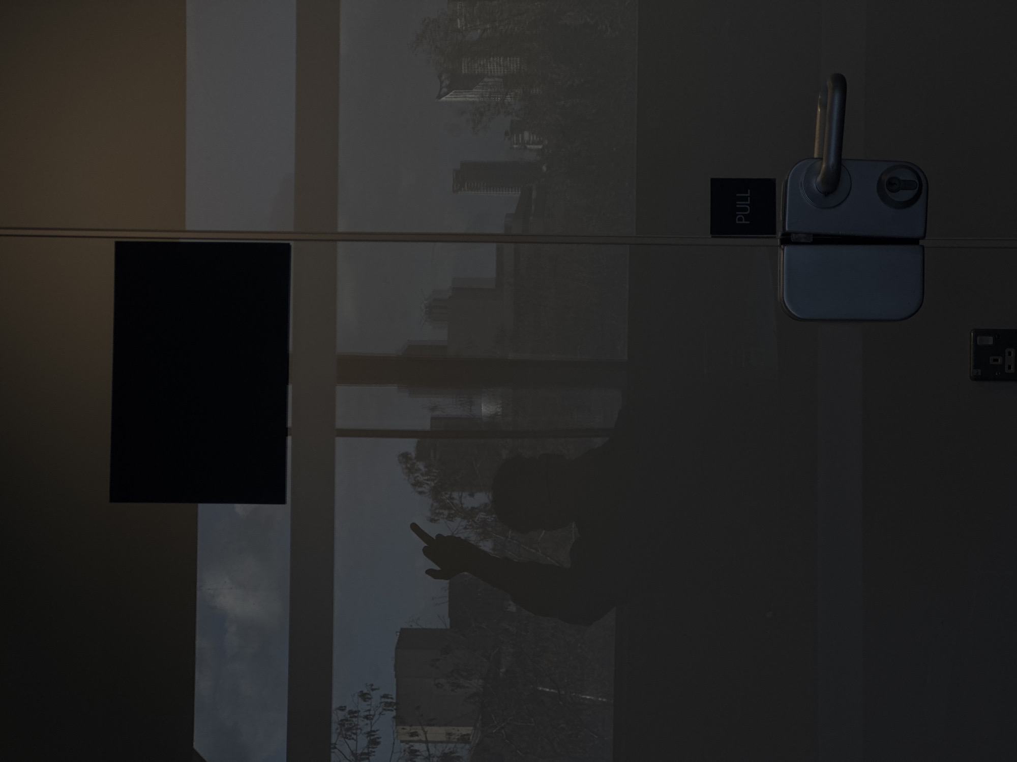 Person's reflection caught in London glass door with cityscape