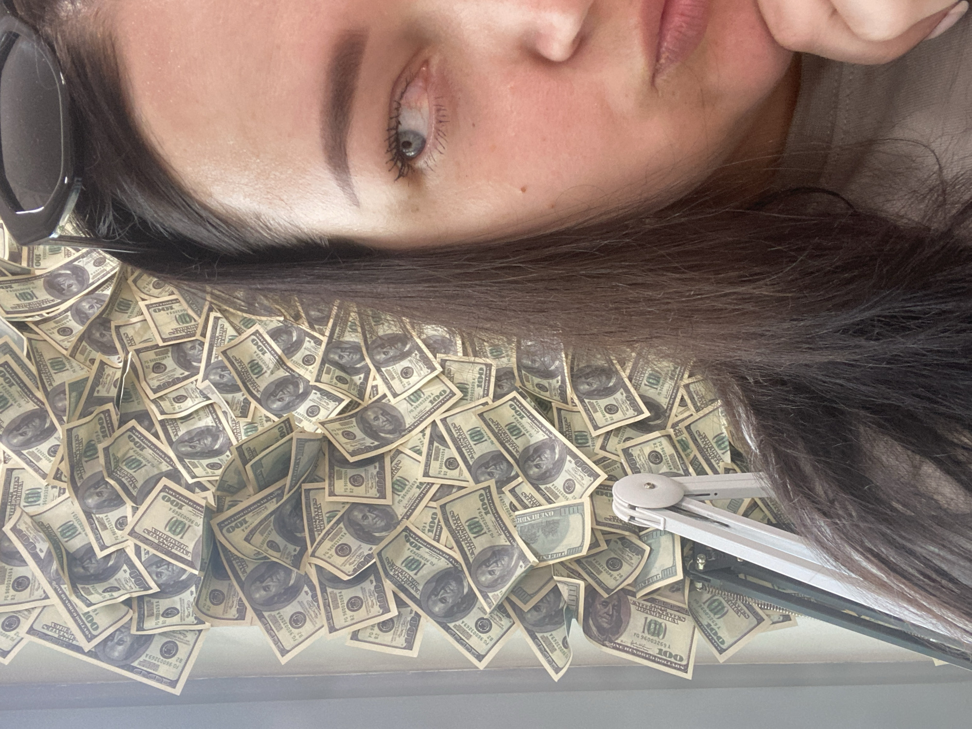 Woman poses with hundred-dollar bills in Sochi nail salon