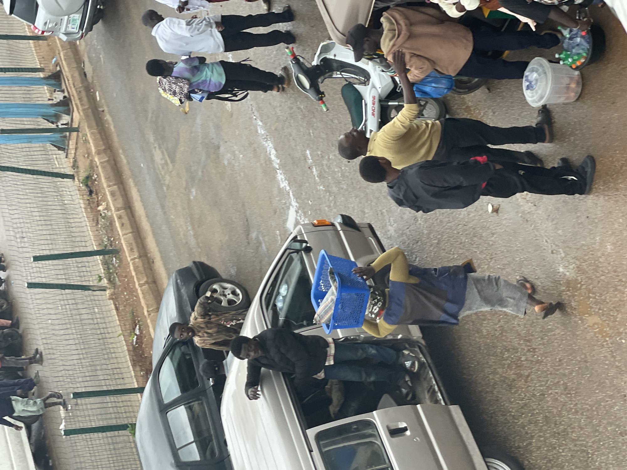 Street market in full swing — vendors, shoppers, and foot traffic