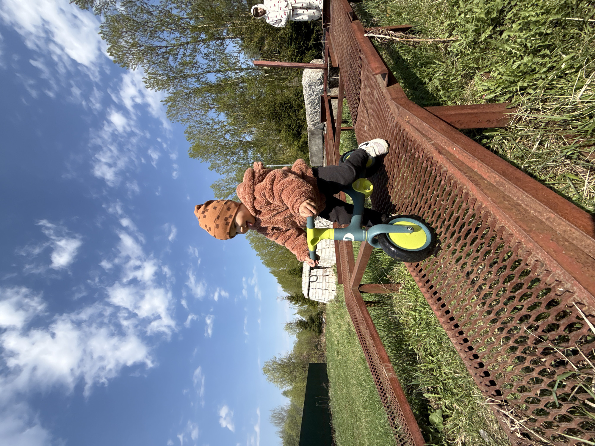 Child rides balance bike in Rusanovo park area