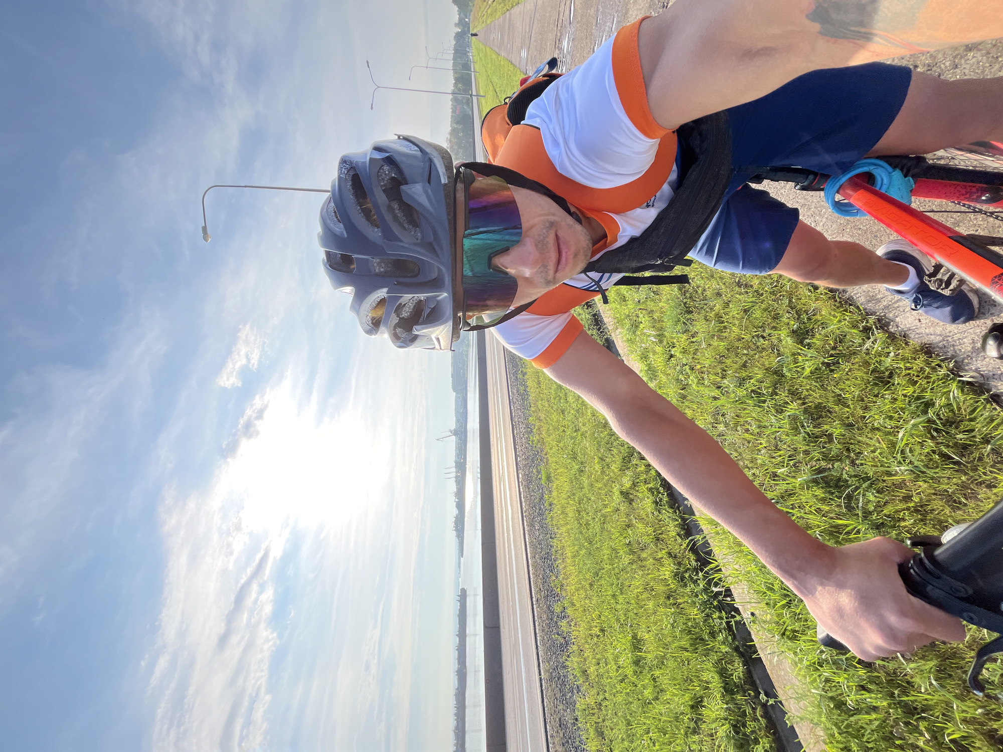 Cyclist rides red bike along Chaikovsky's waterfront paths