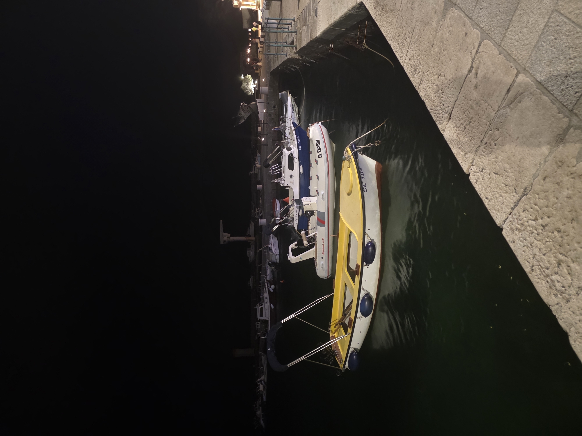 Nighttime harbor town scenes with cannons, boats, and a passing storm