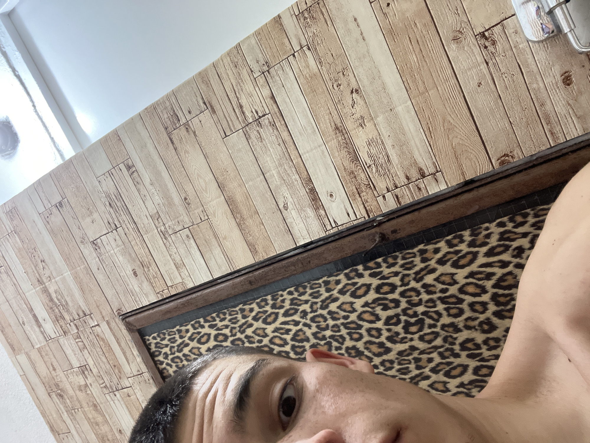 Portrait captured against leopard-print headboard in Sopot, Bulgaria