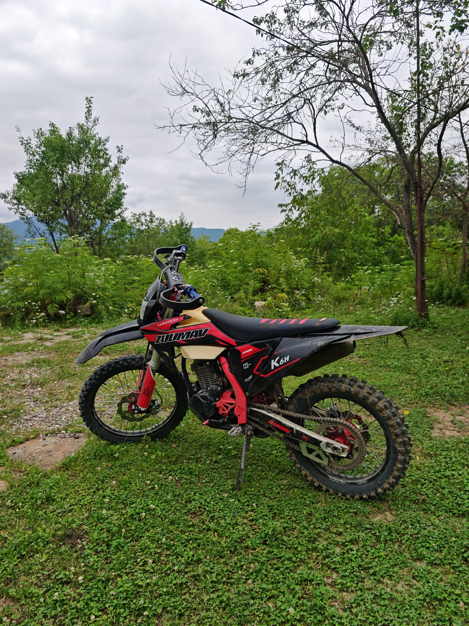 Dirt bikes parked on a wooded hillside in Sherdy-Mokhk