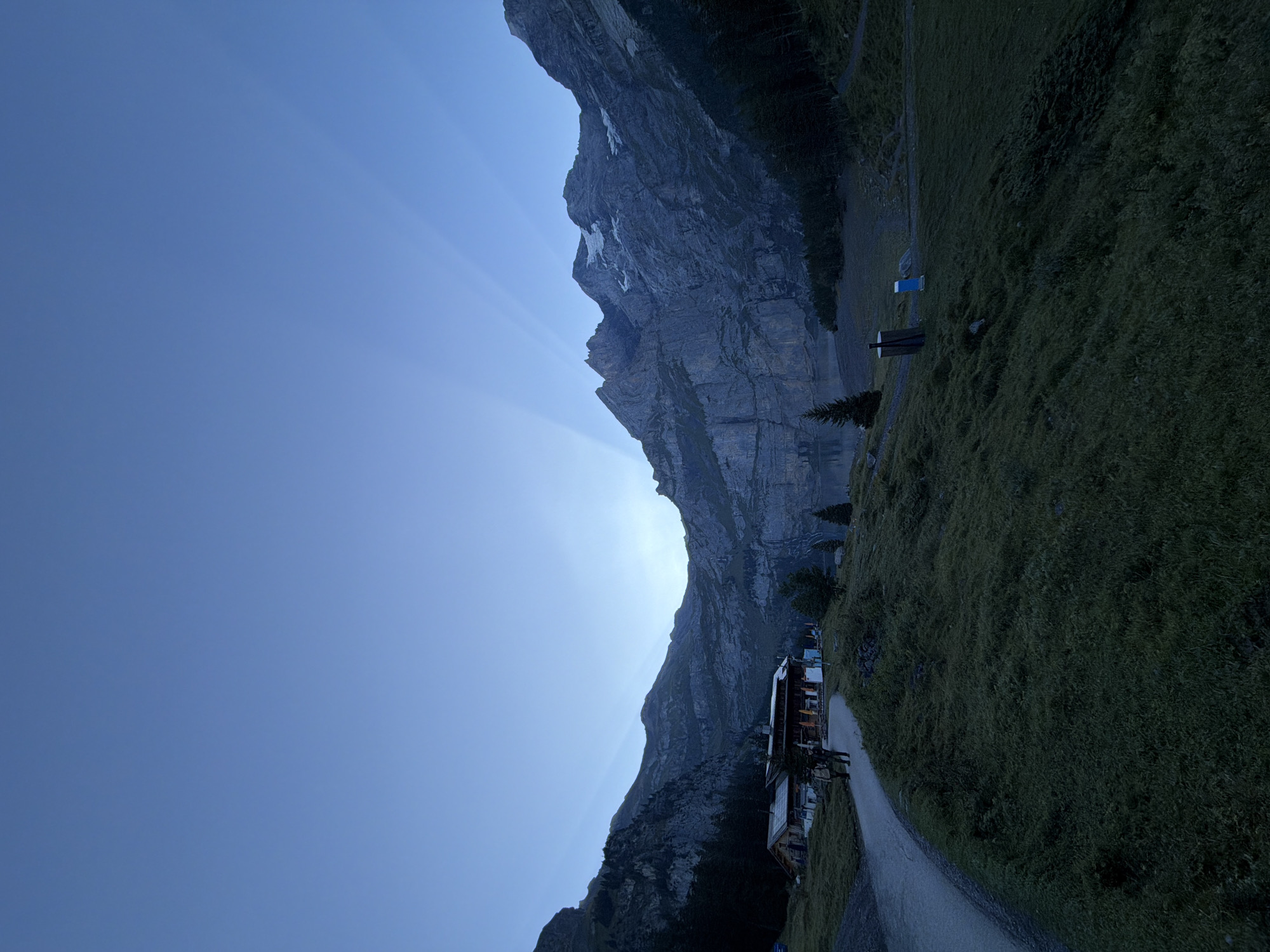 Dawn breaks over Oeschinensee as cows settle in nearby pasture