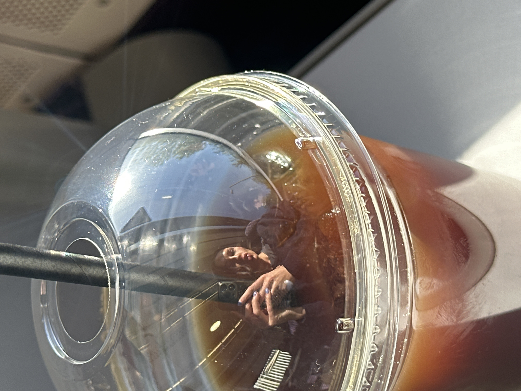 Woman drinks iced coffee on train in Tunbridge Wells