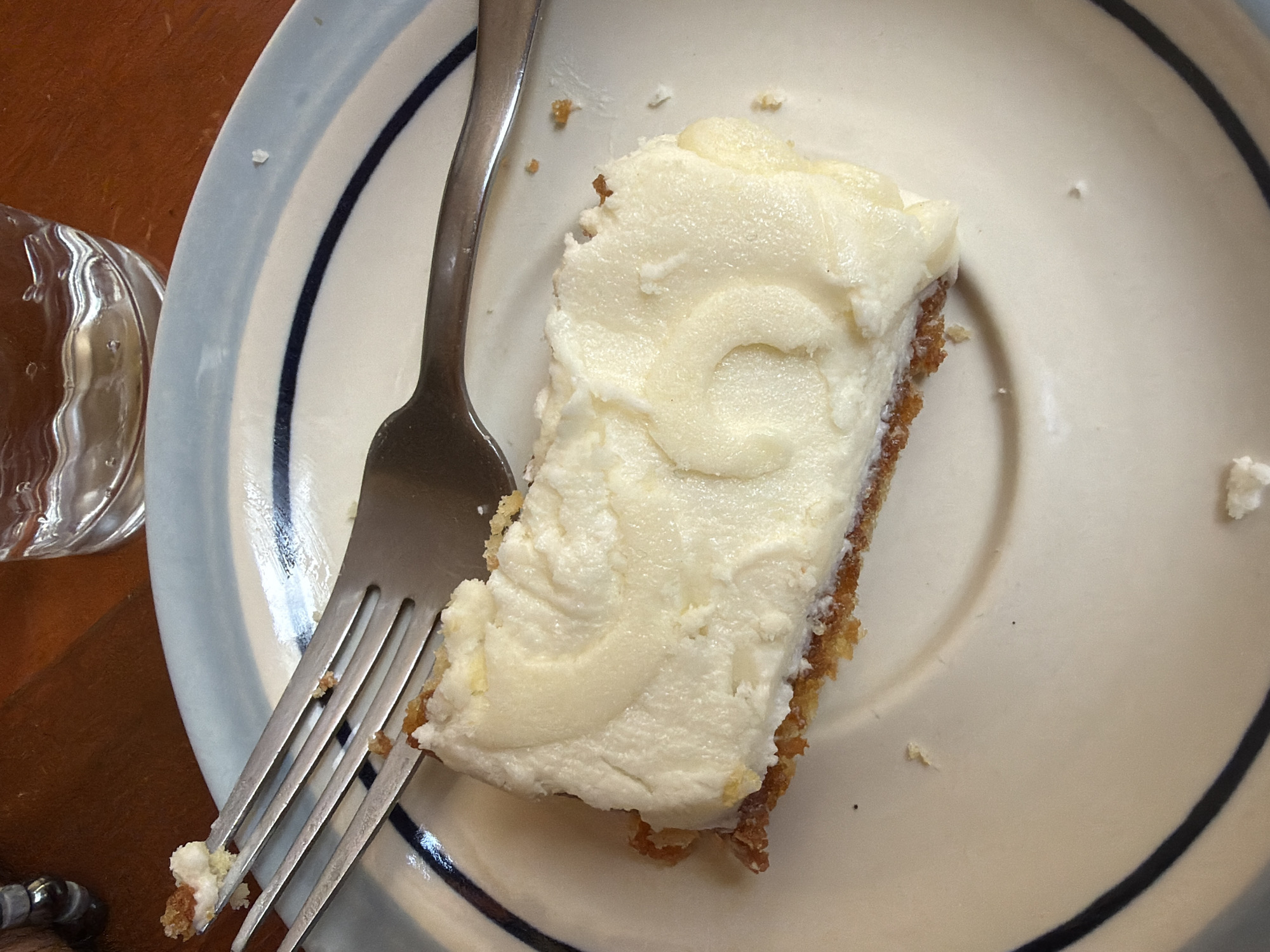 Person enjoys slice of cake during evening meal