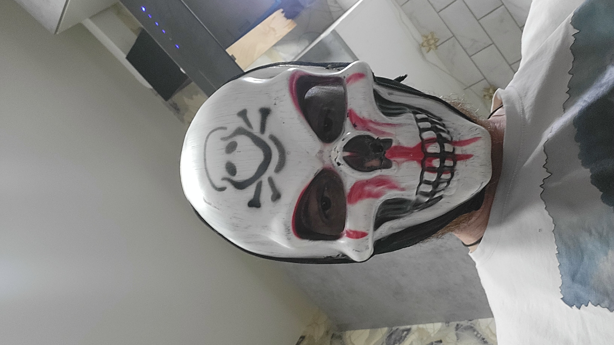 Masked Individual Spotted Near Lit Sports Field at Night