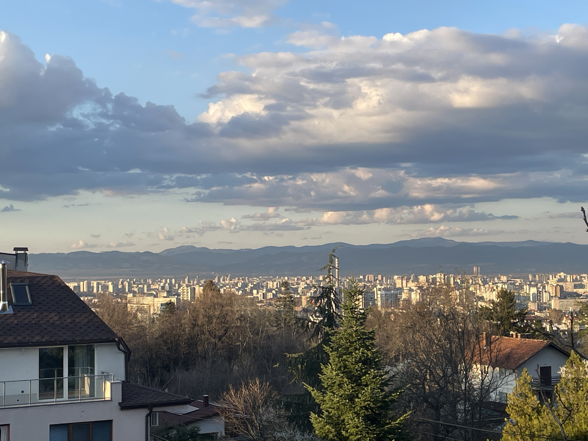 Sofia cityscape documented under cloudy skies with mountain backdrop