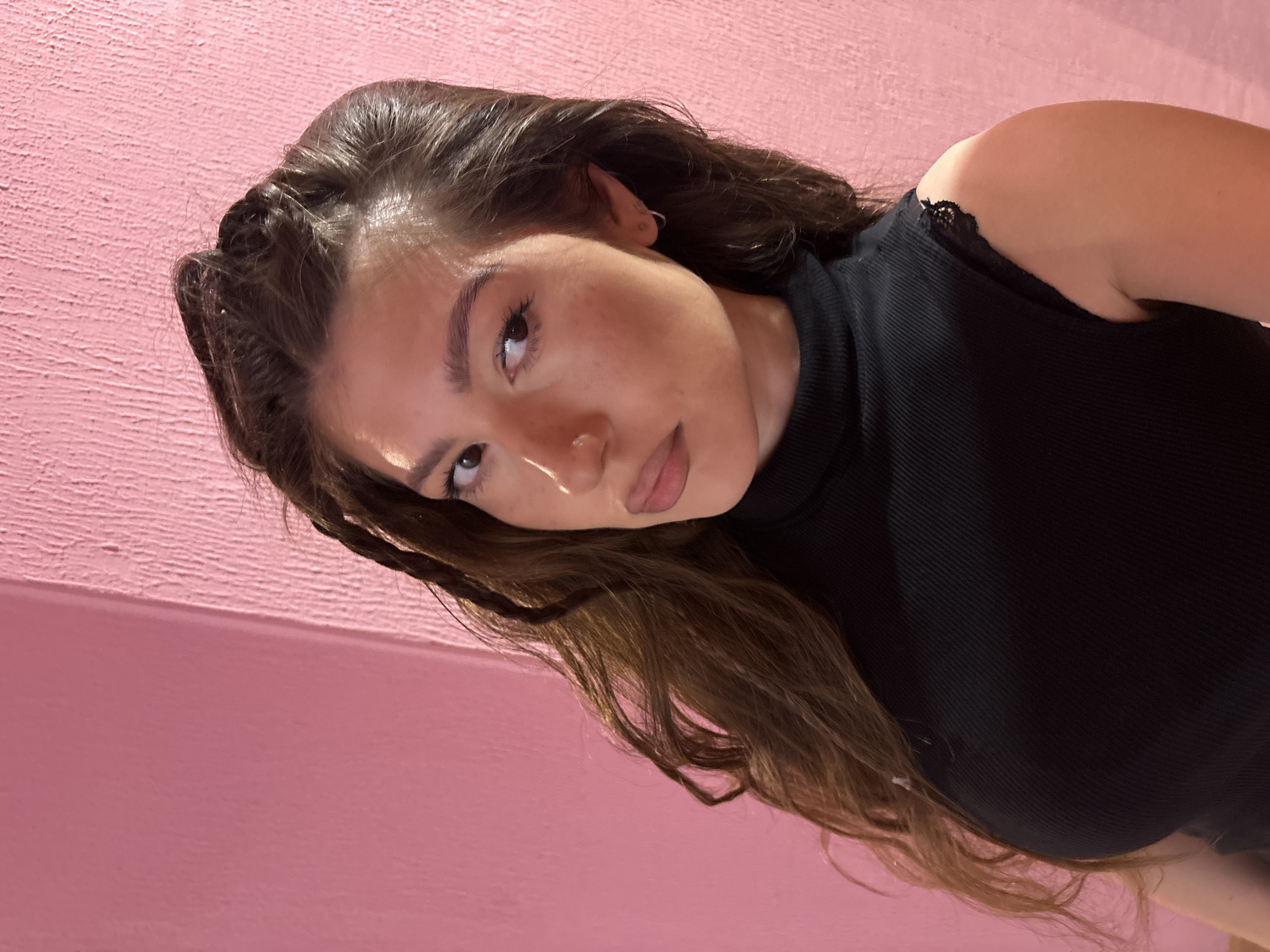 Woman takes early morning selfies against pink wall in Kazan
