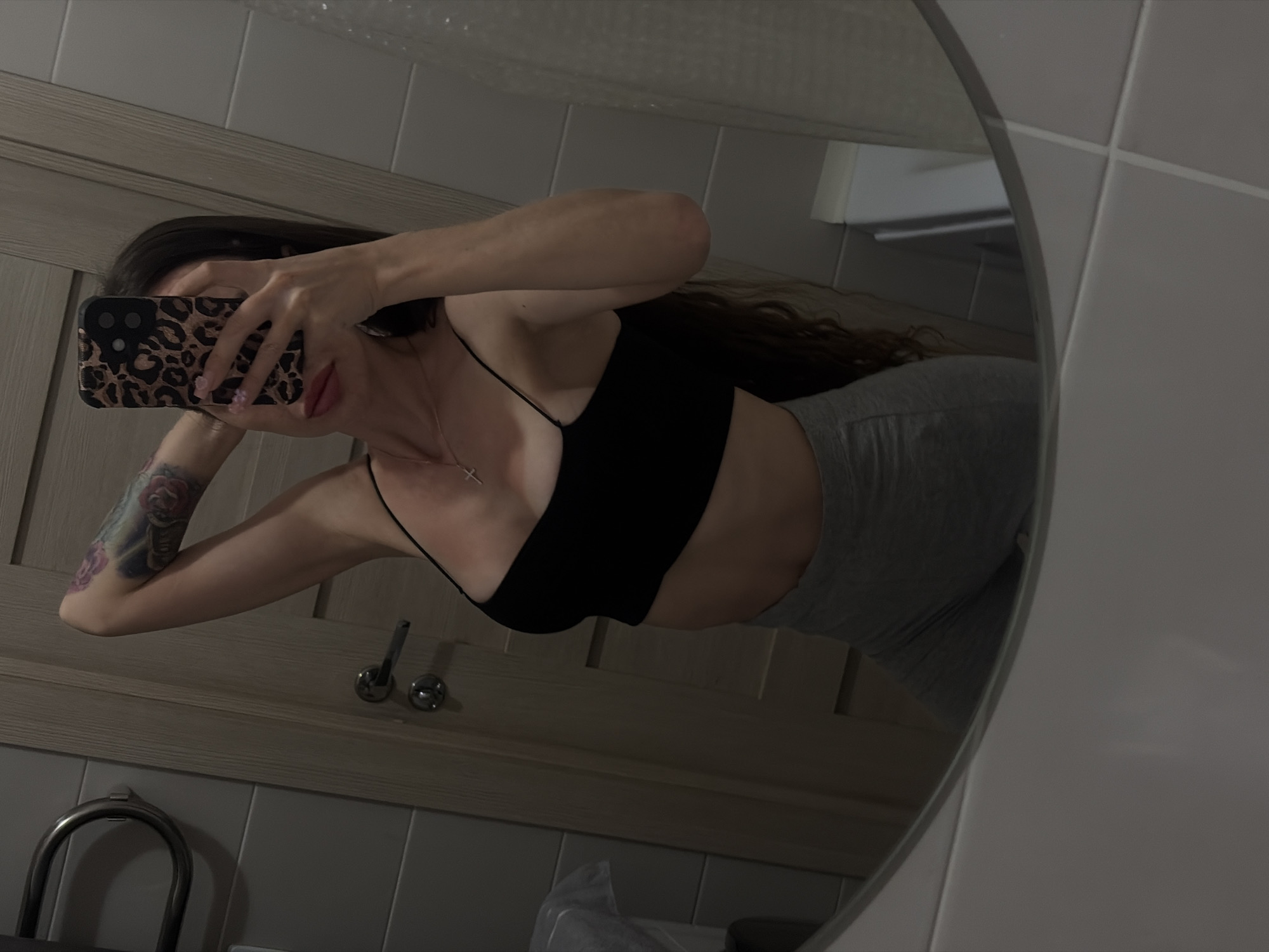Woman documents skincare routine in bathroom mirror selfies