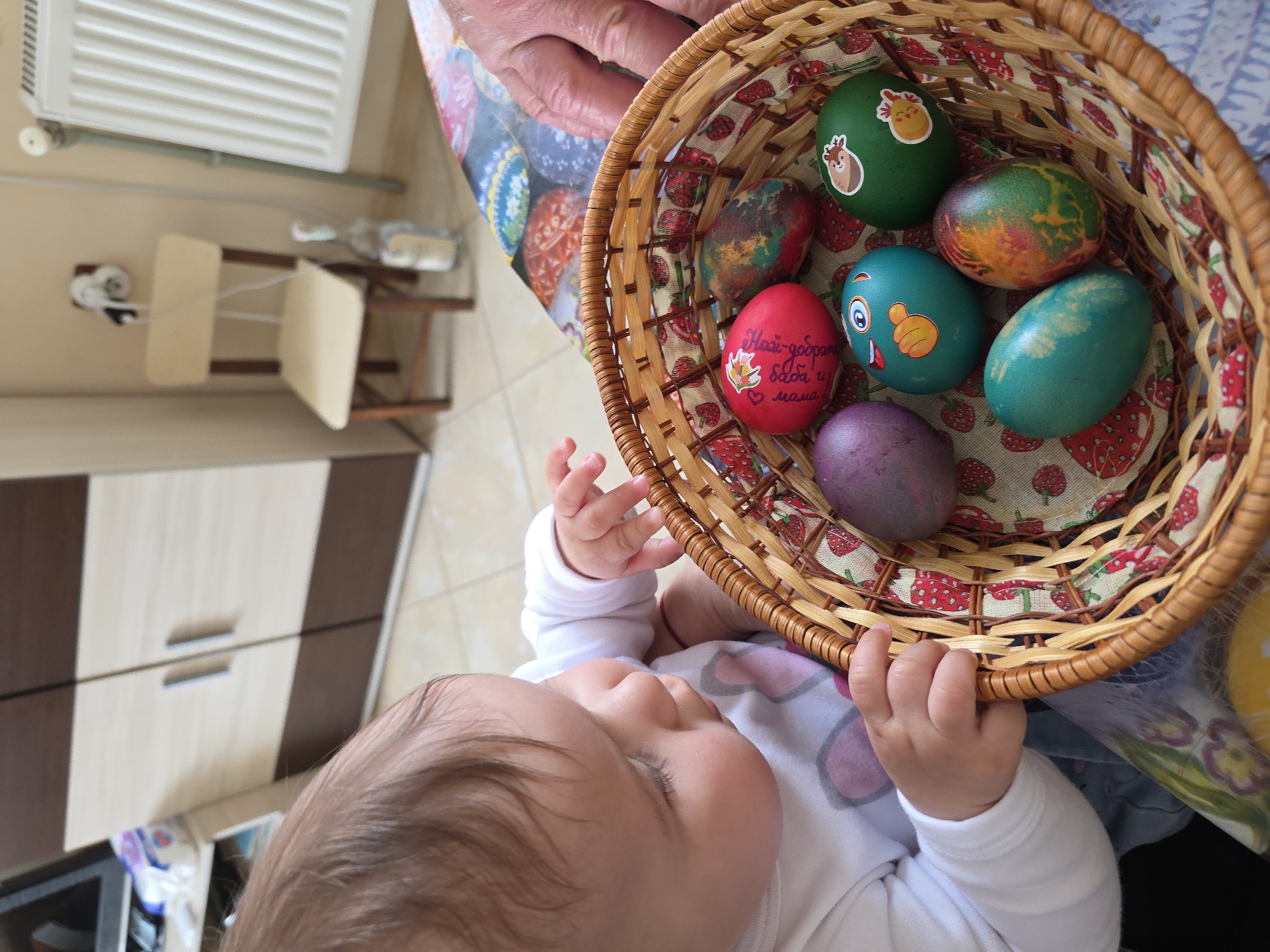Baby reaches for Easter eggs in Bulgarian apartment complex
