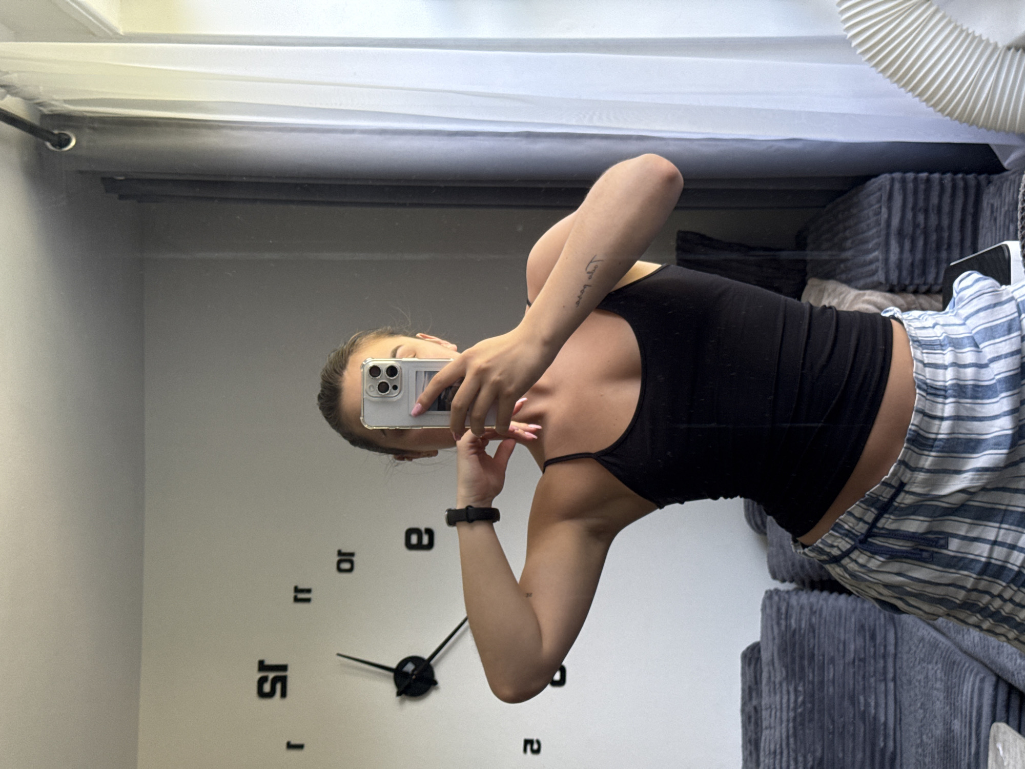 Mirror selfie in a New York apartment with a fire escape view