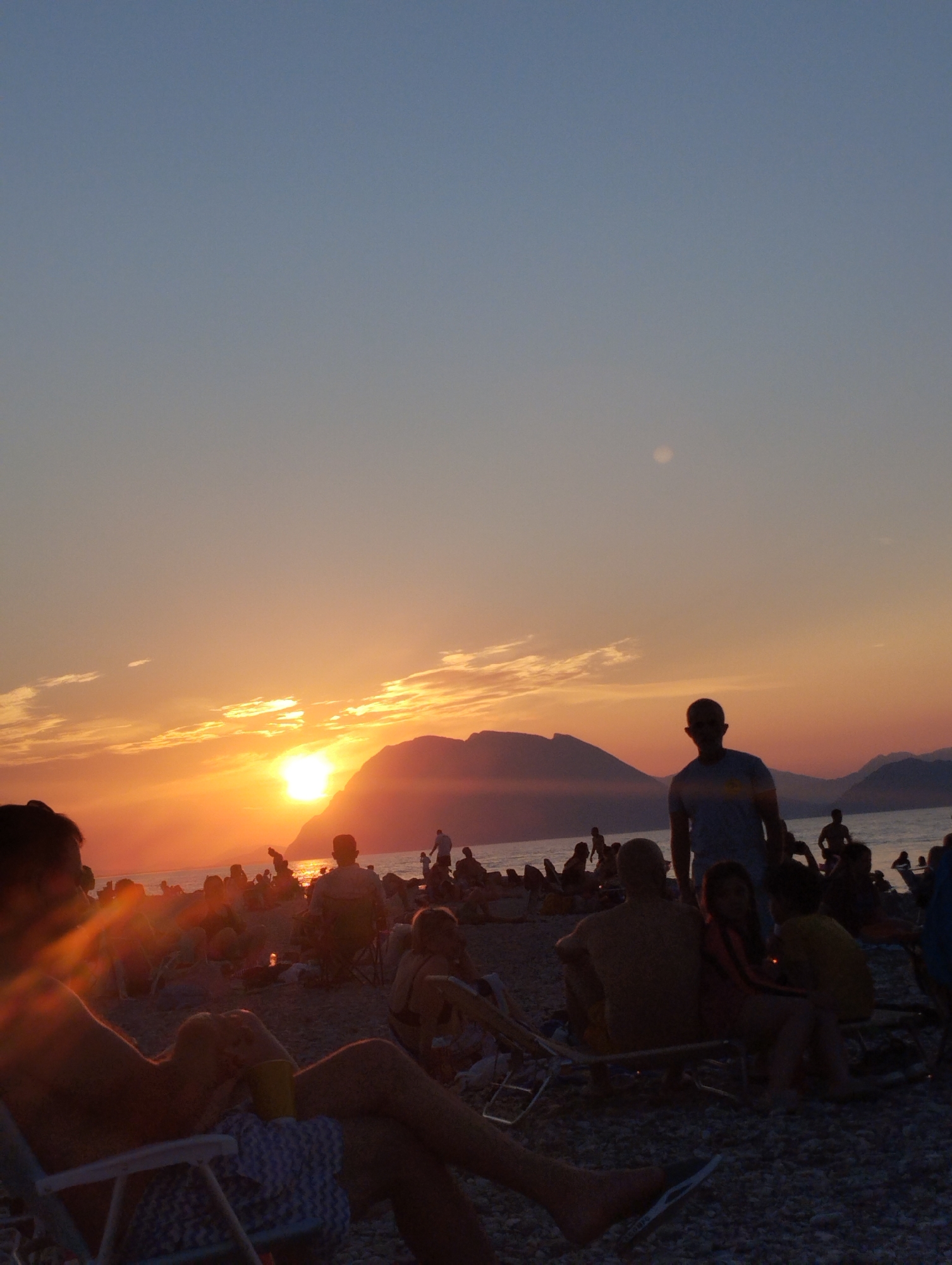 Beachside sunset watch from a rocky shoreline at dusk