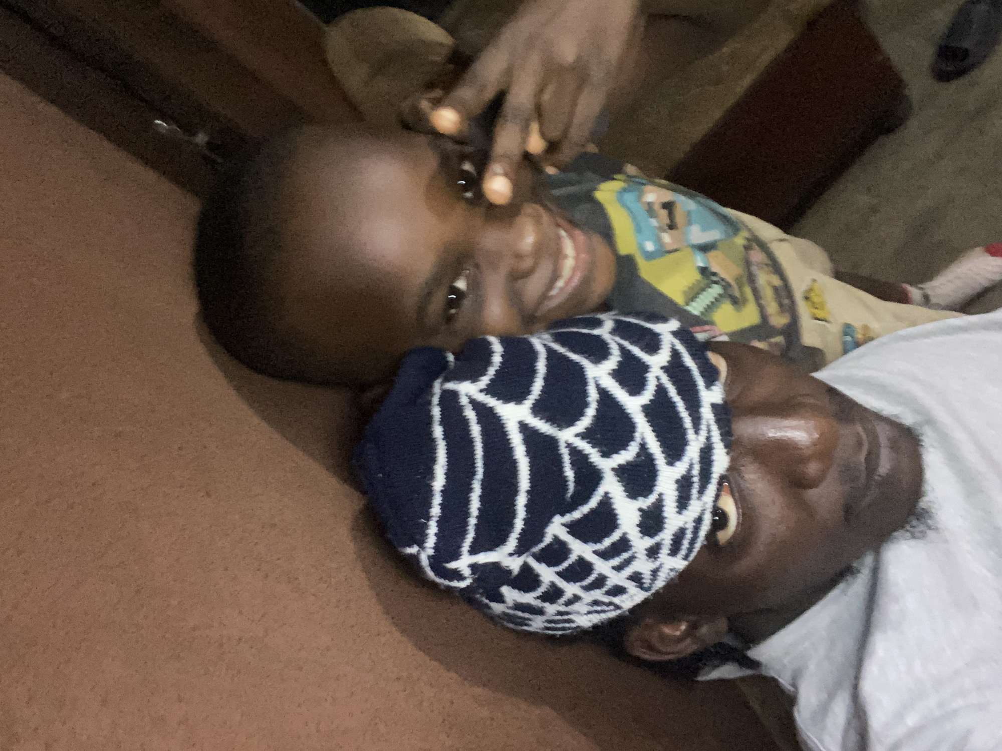 Child and adult share playful moments in Alagba home