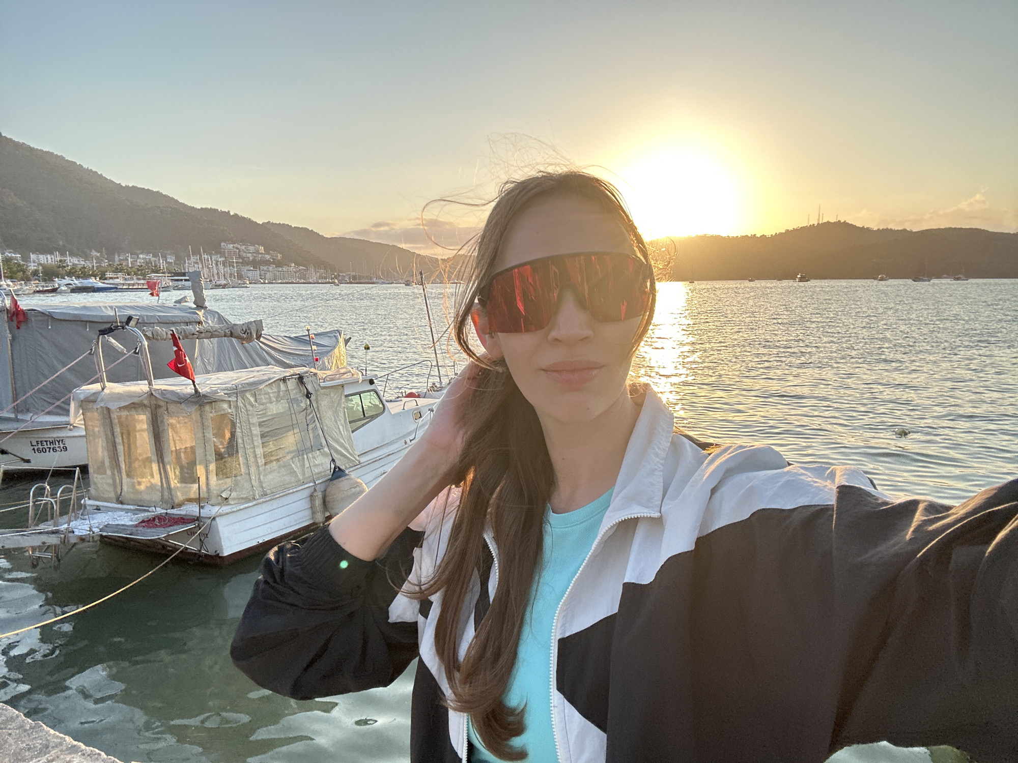 Woman captures sunset selfie at Fethiye harbor, Turkey