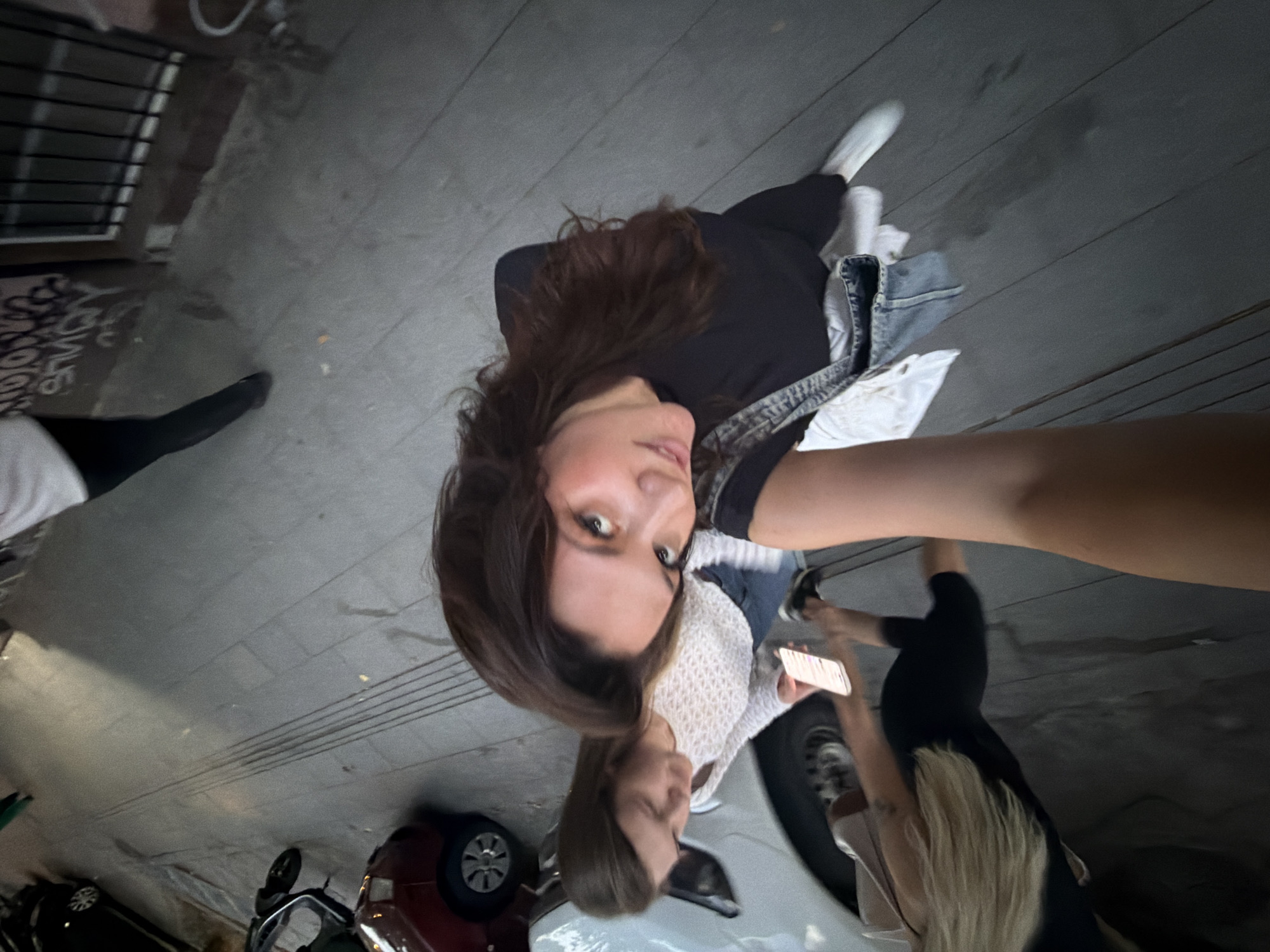 Young women take selfies while walking Belgrade sidewalk