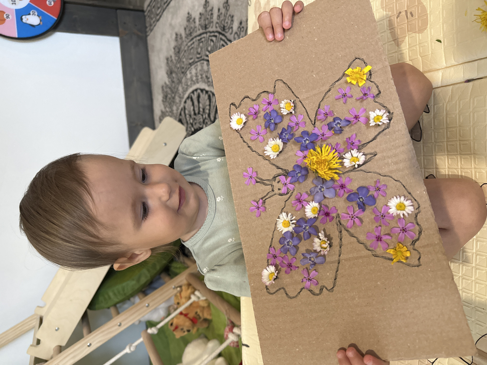 Toddler creates flower butterfly art in Wisła play area