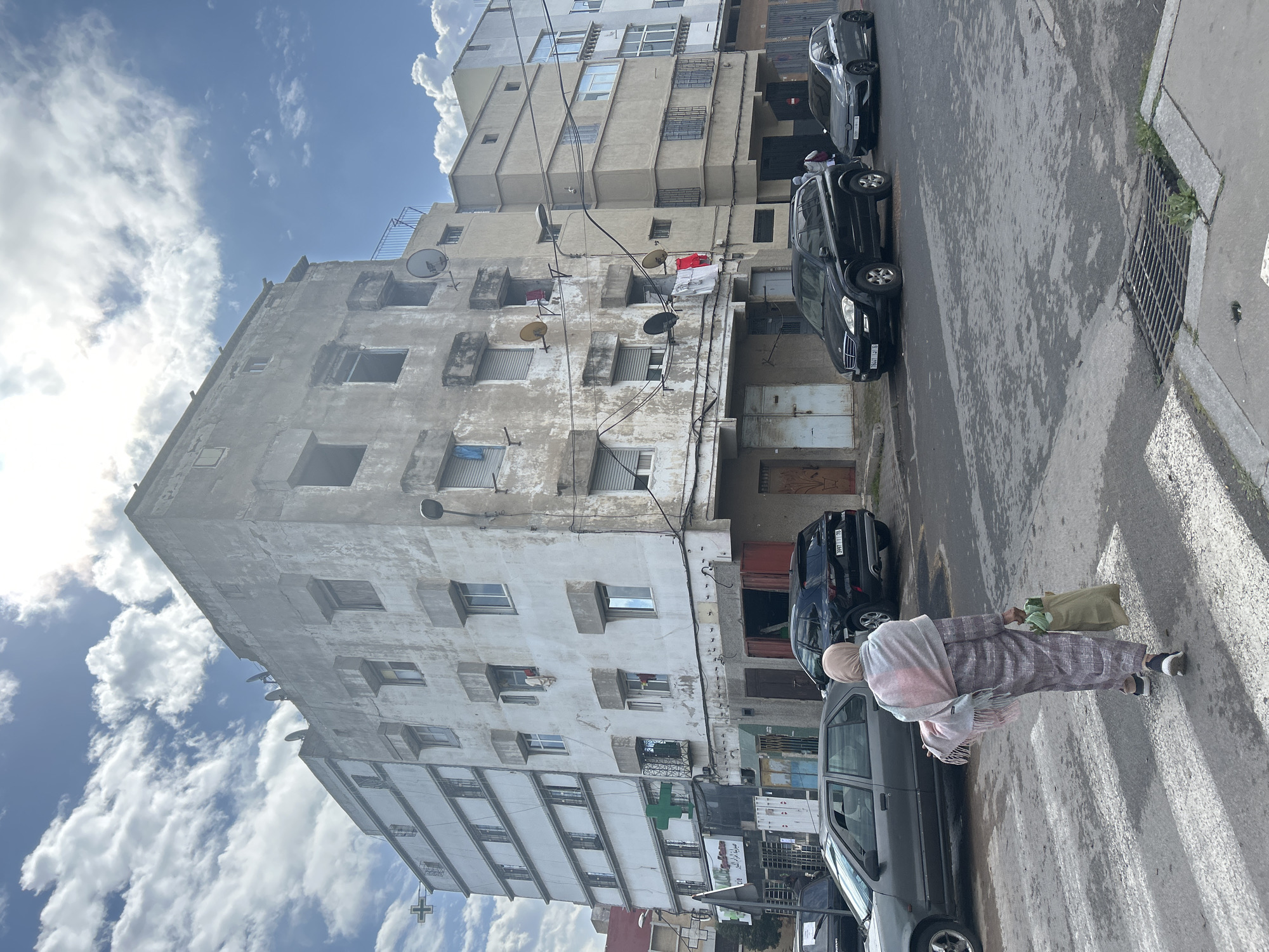 Woman crosses street in Casablanca carrying green bag