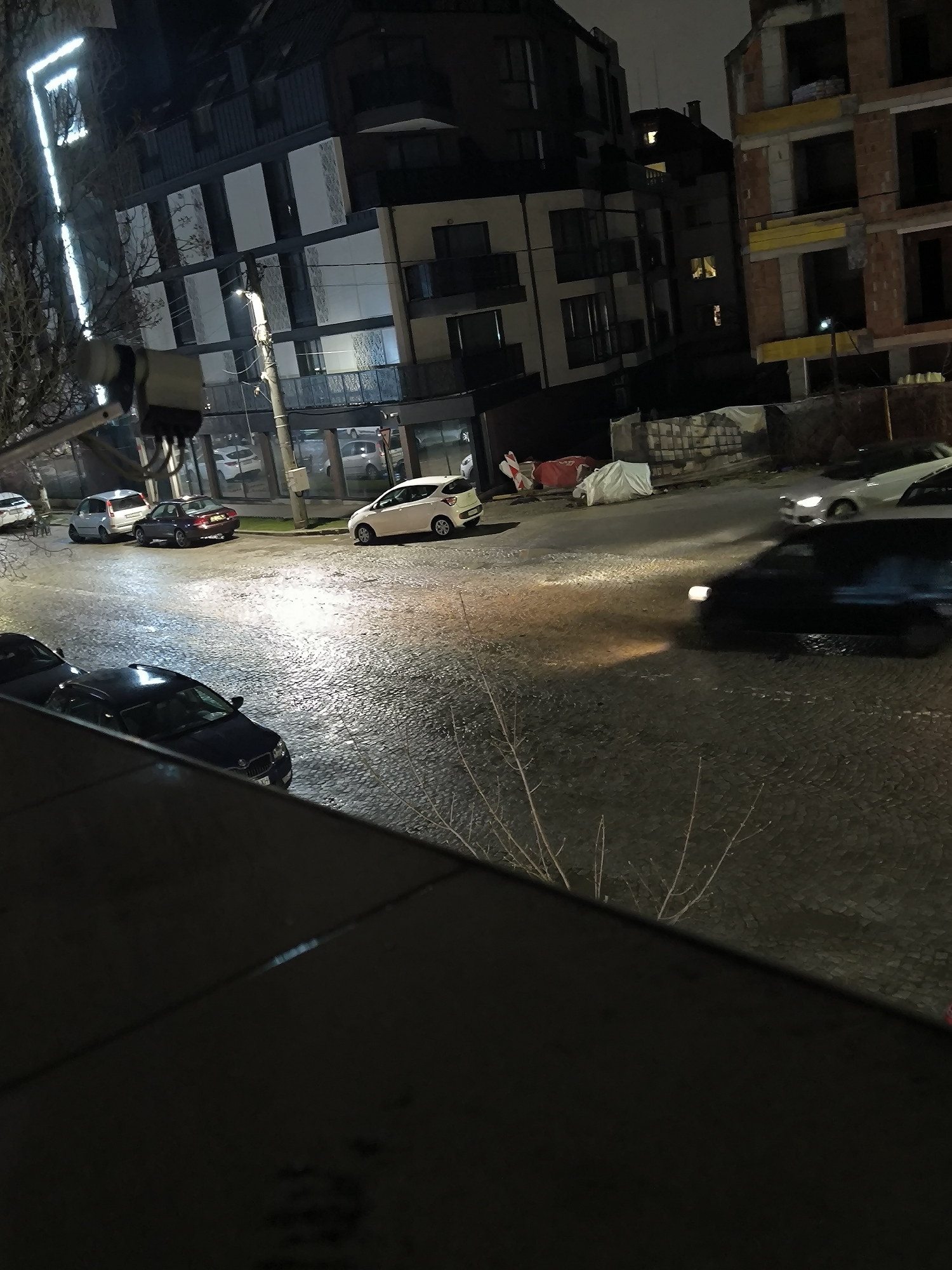 Wet cobblestone street scene captured at night in Sofia