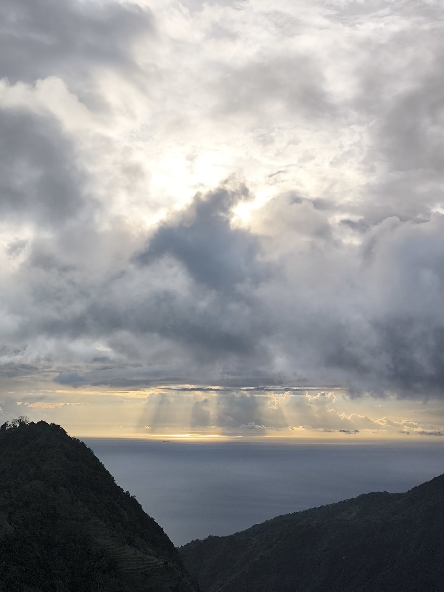 Dramatic cloudy skies illuminate mountainous coastline in Abang, Indonesia