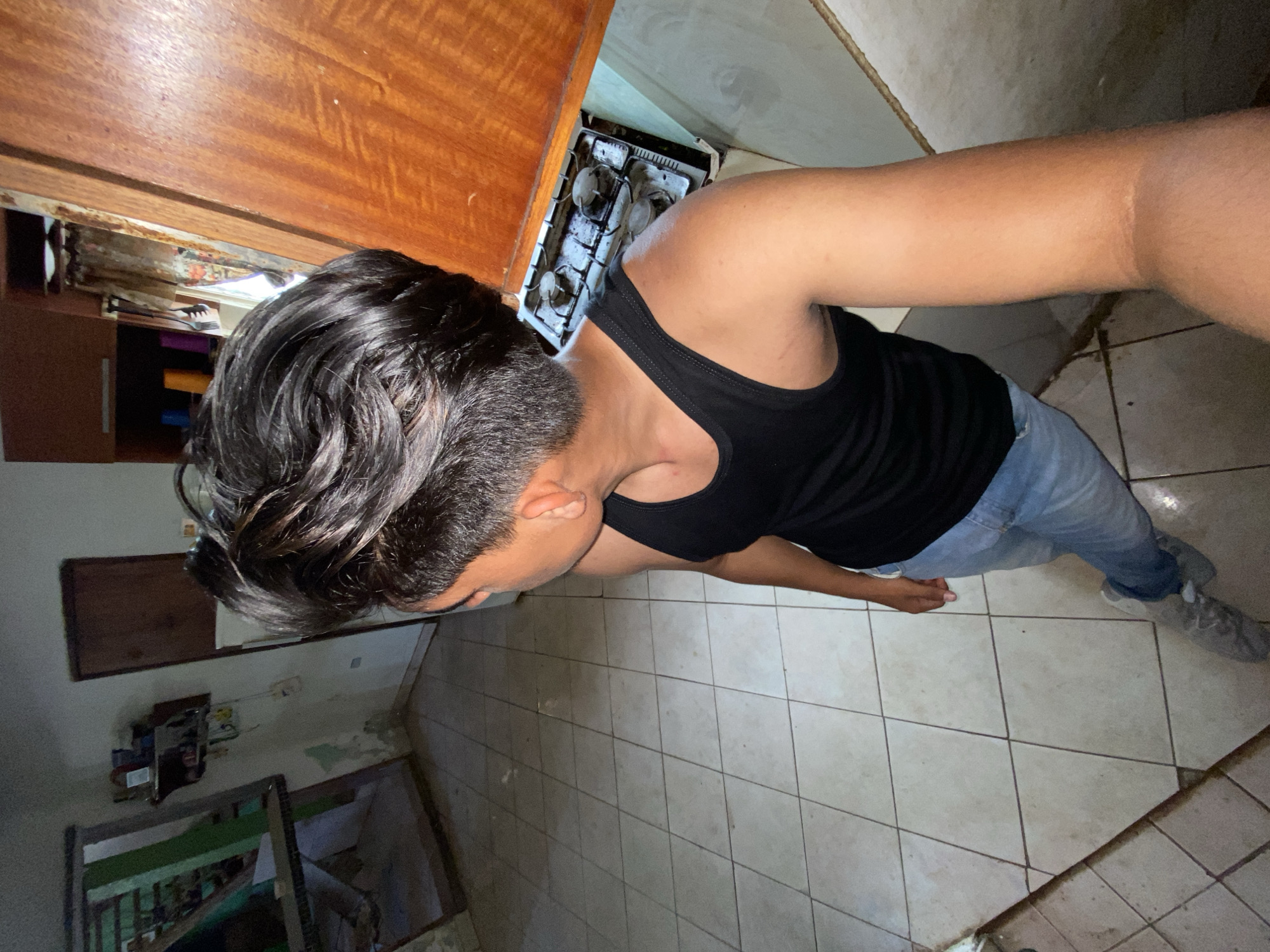 Man documents evening meal preparation routine in Venezuelan kitchen