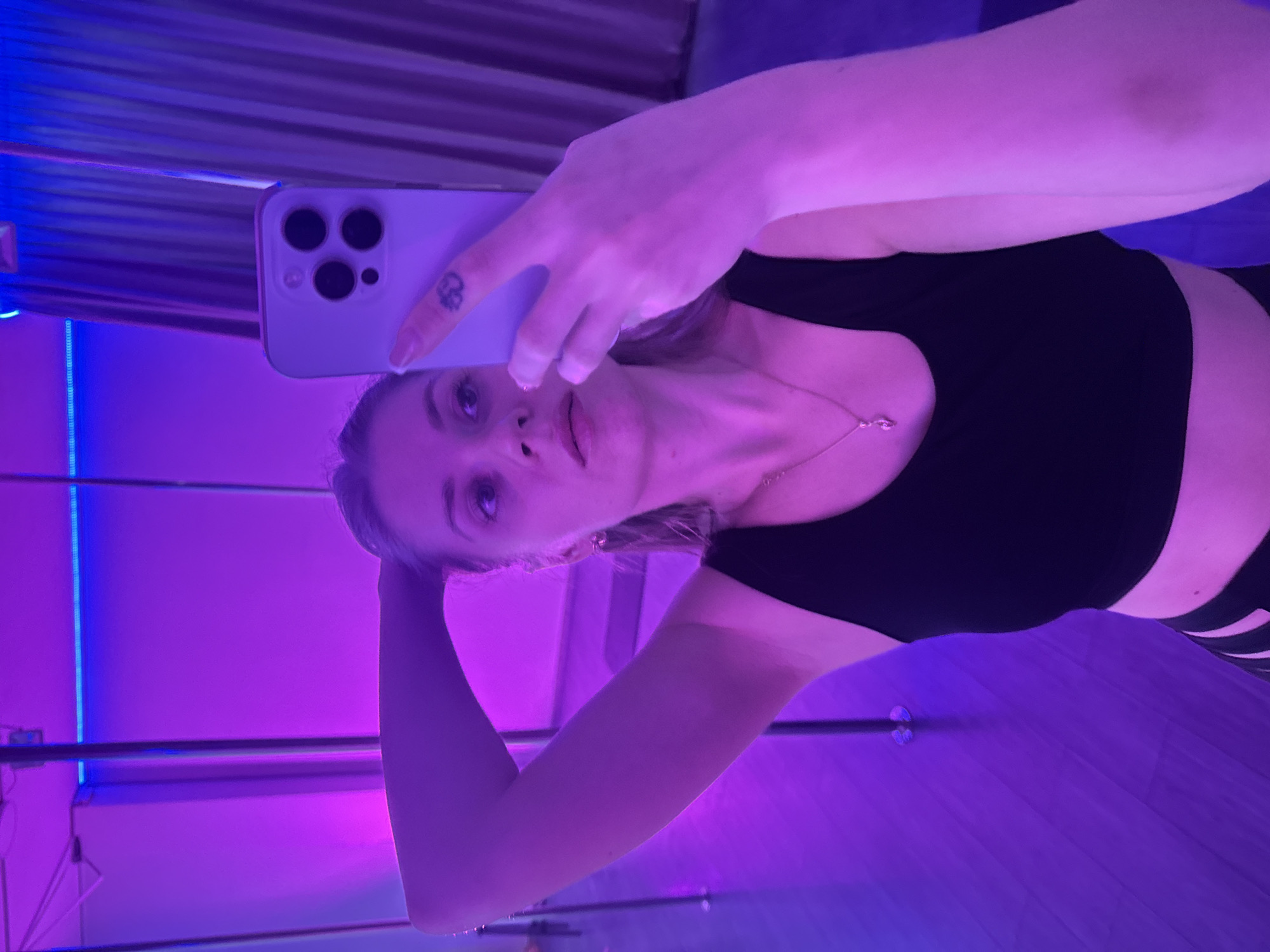 Woman takes selfies in colorful lit room in Batumi