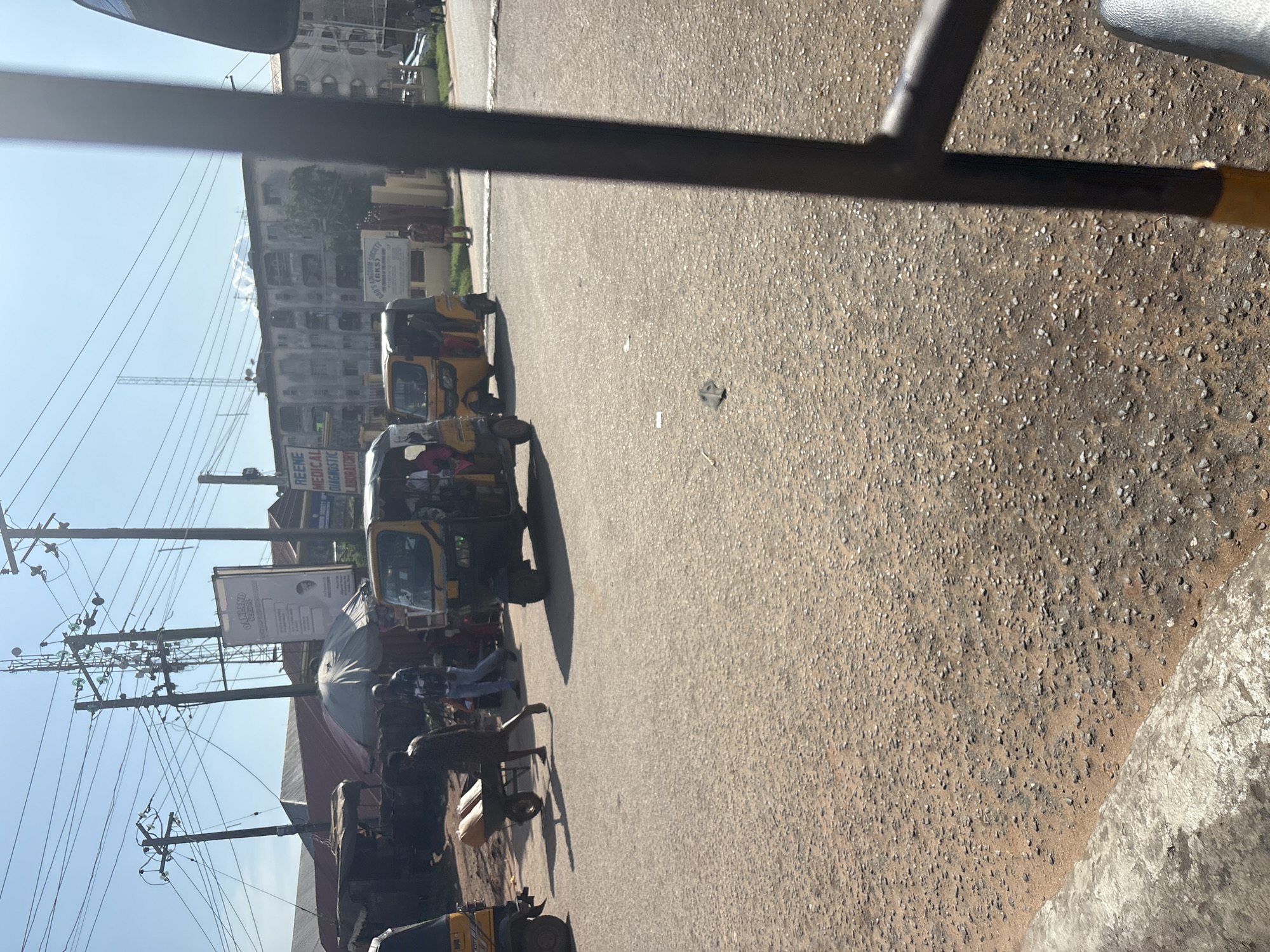 Inside and outside a Keke Napep on a Nkpor street