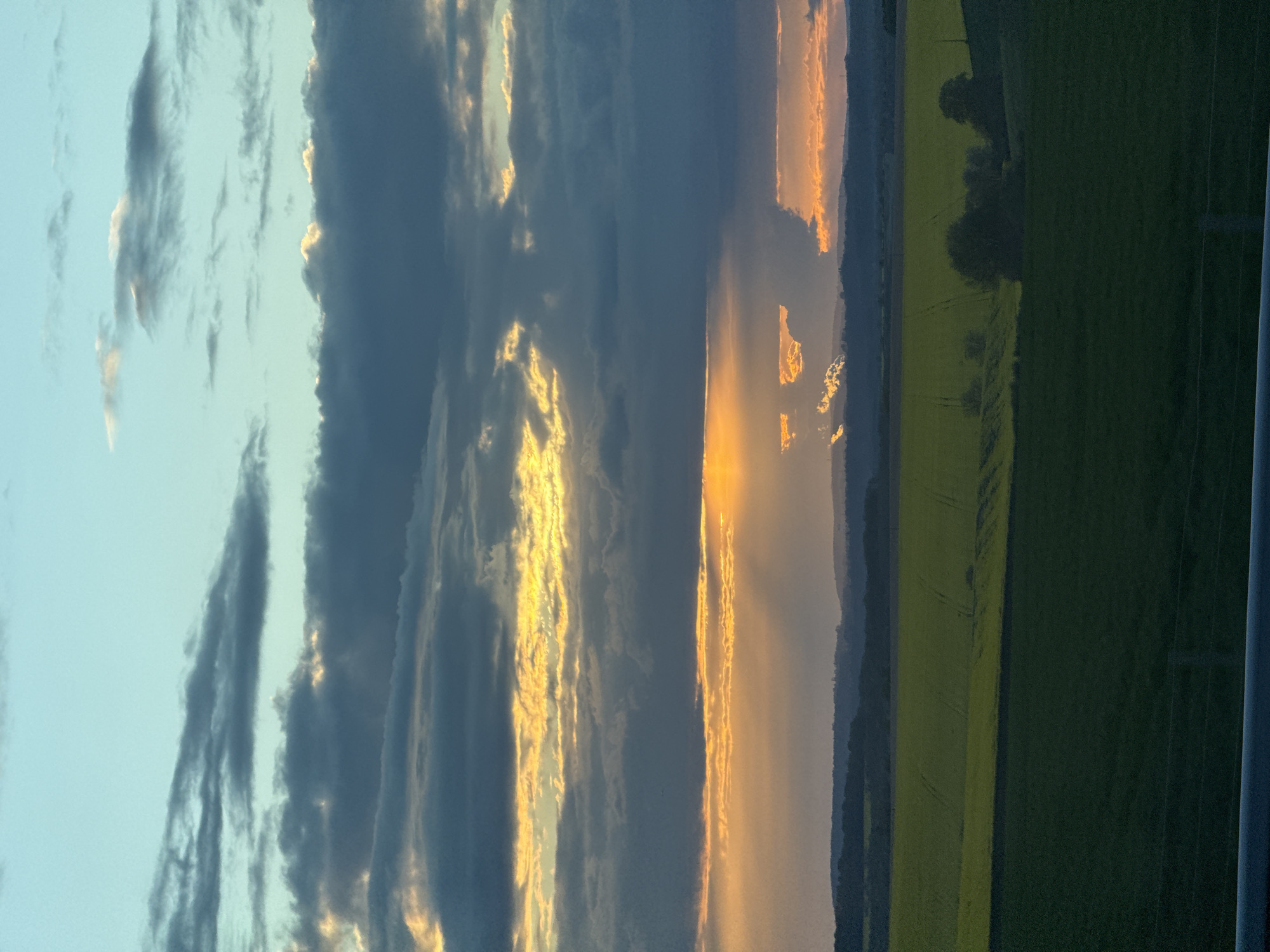 Dramatic golden sunset observed through storm clouds in Jaignes
