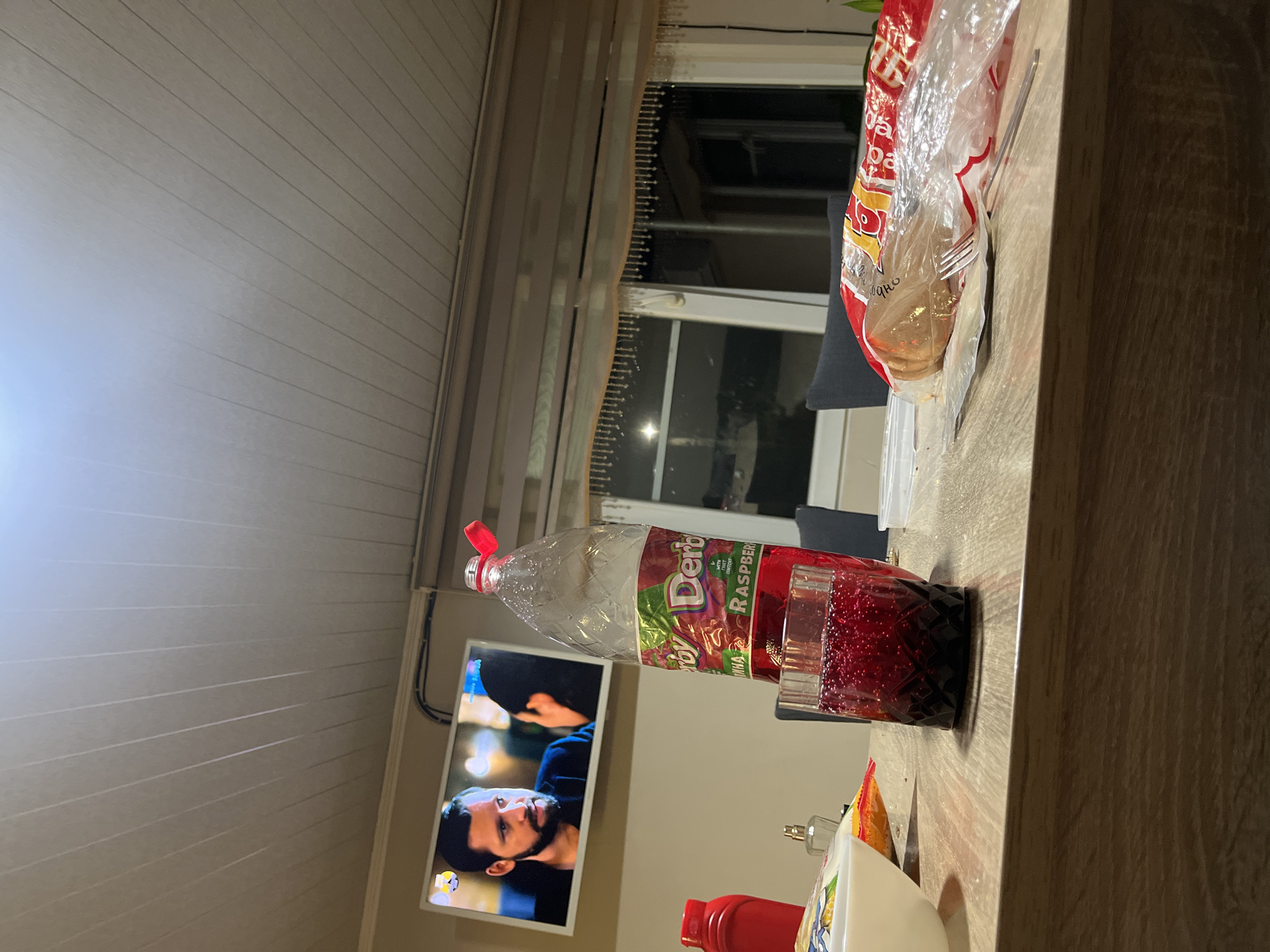 Person enjoys drink while watching TV in Bulgarian home