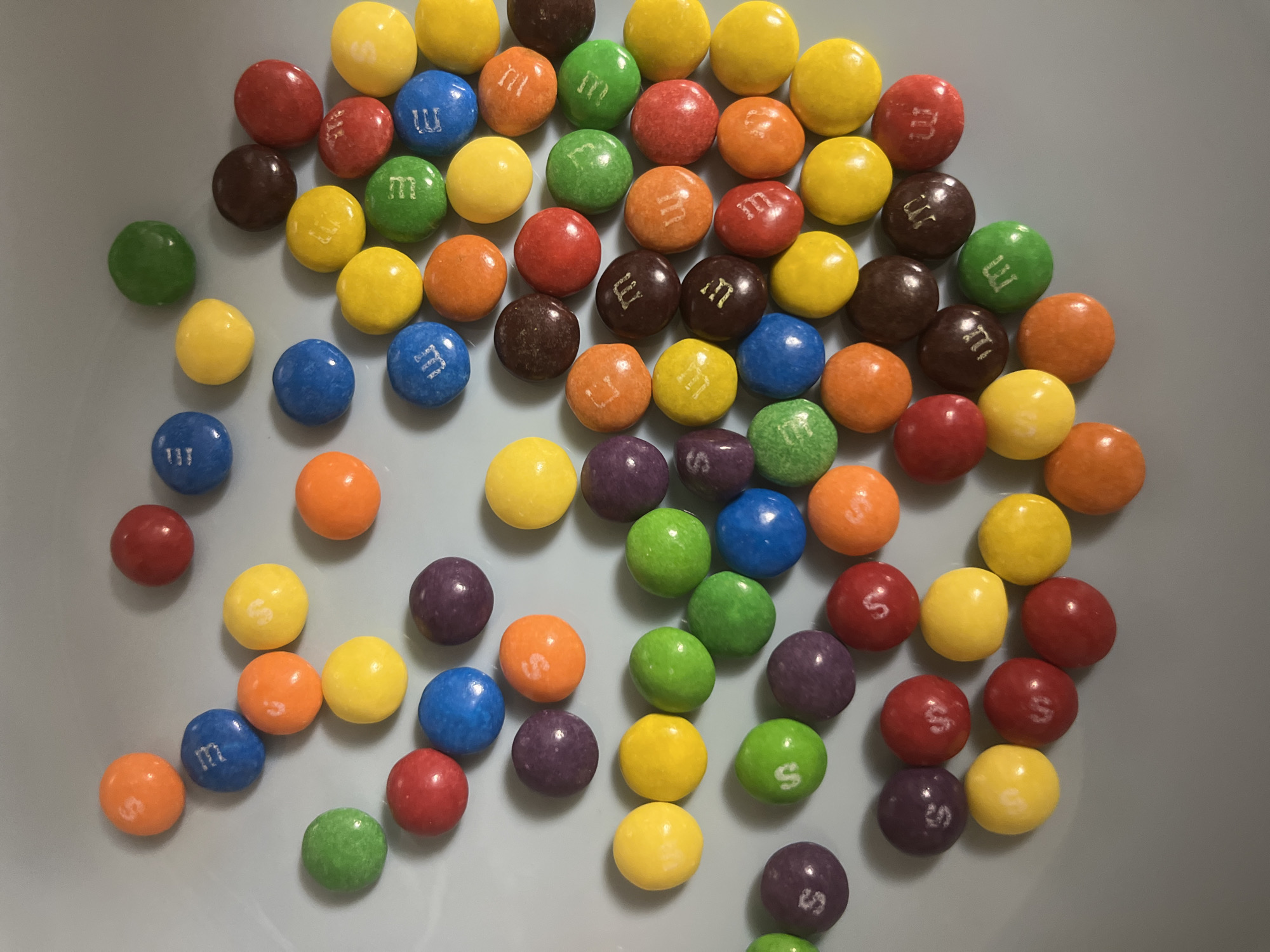 Scattered M&Ms and computer mouse observed on home surfaces