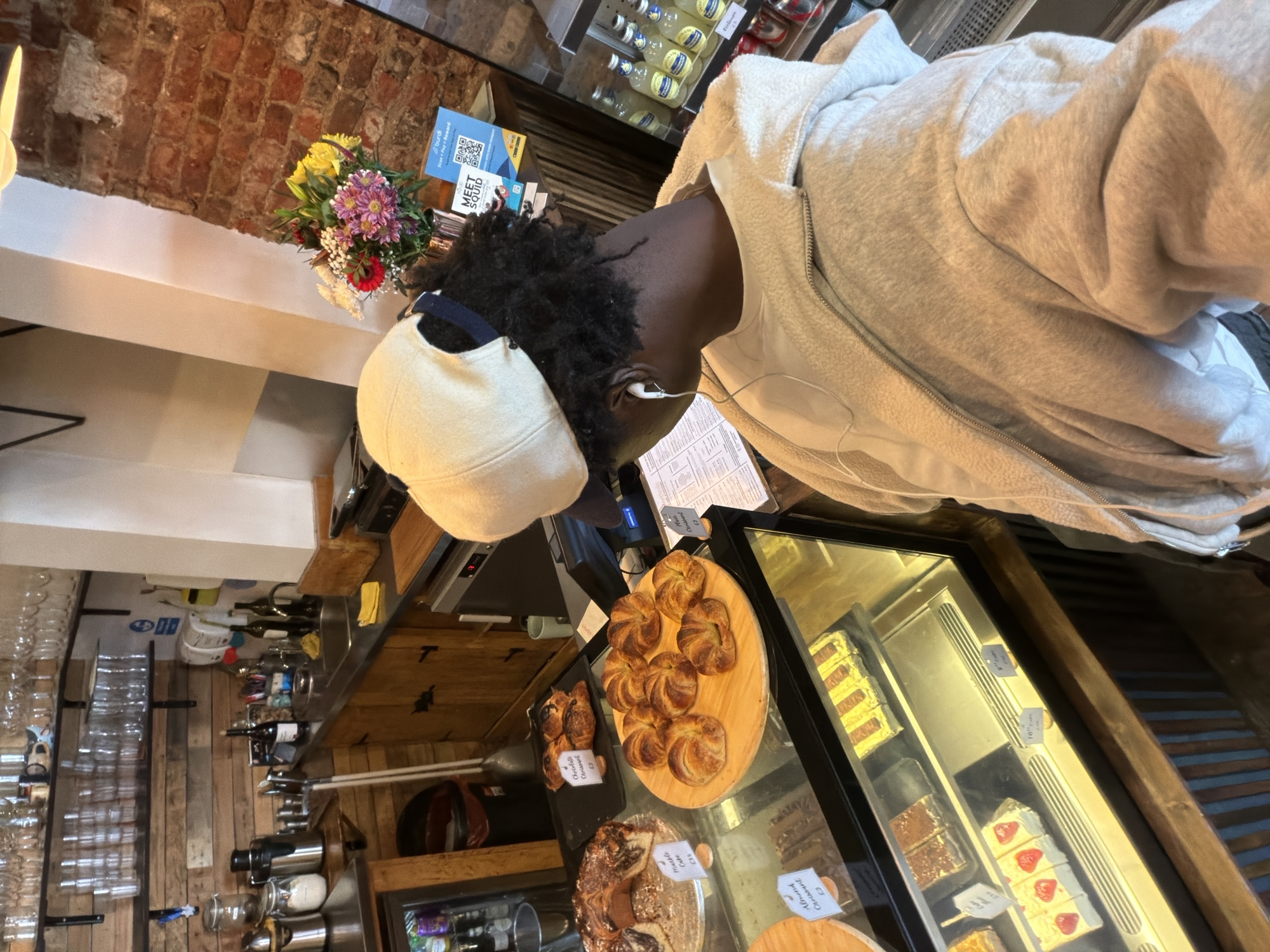 Customer browses baked goods at London cafe counter