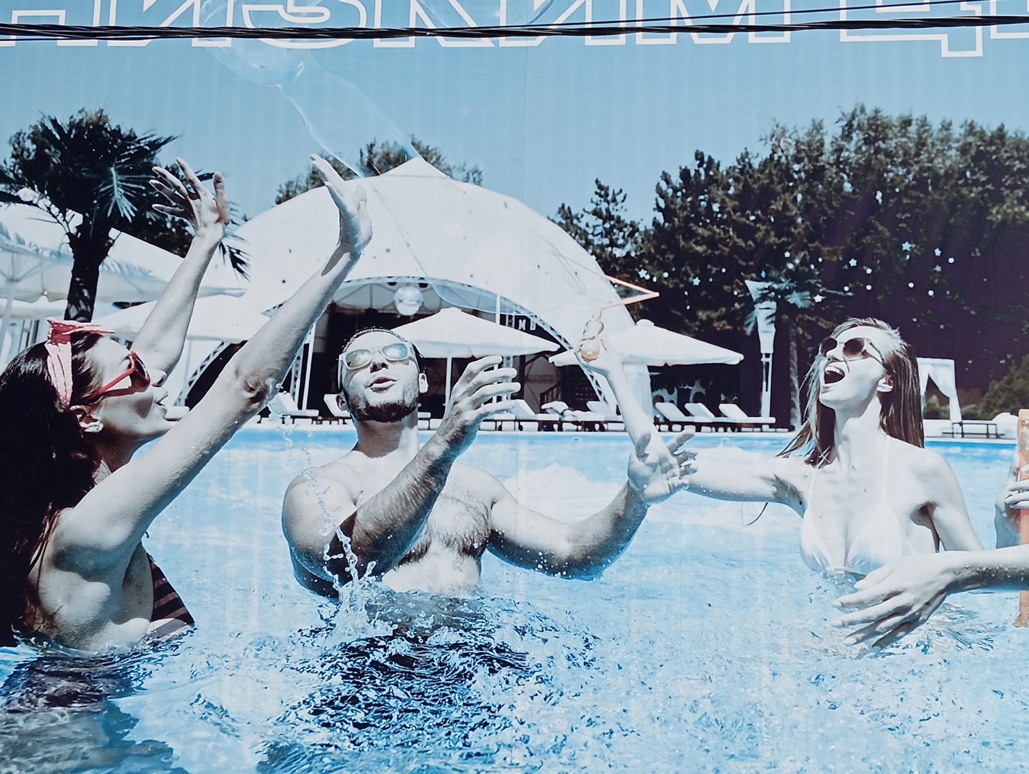 Resort-themed banner featuring swimmers displayed in Yalangach, Uzbekistan