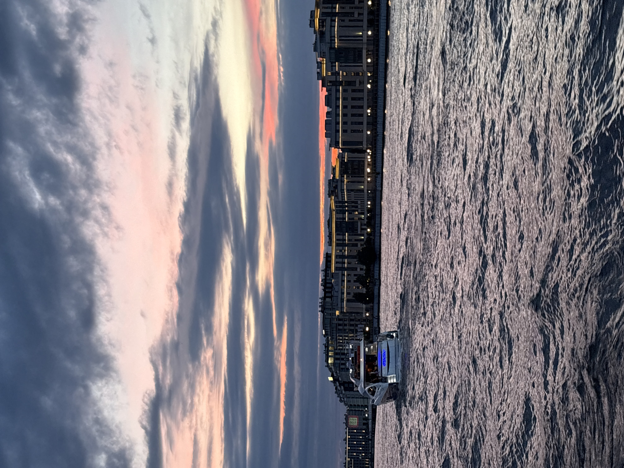 Evening boat party drifting past Saint Petersburg's lit waterfront