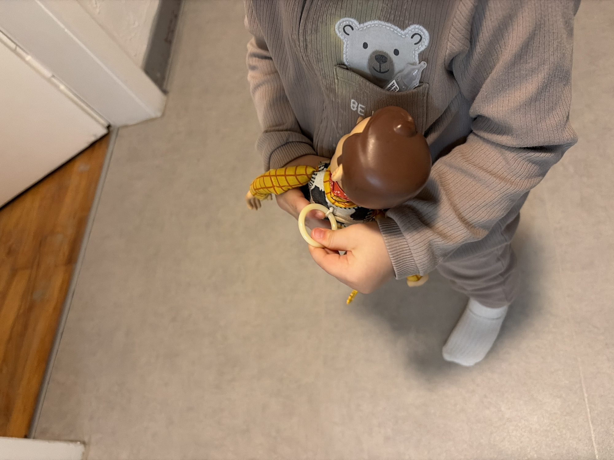 Child plays with Woody doll at home in Luxembourg