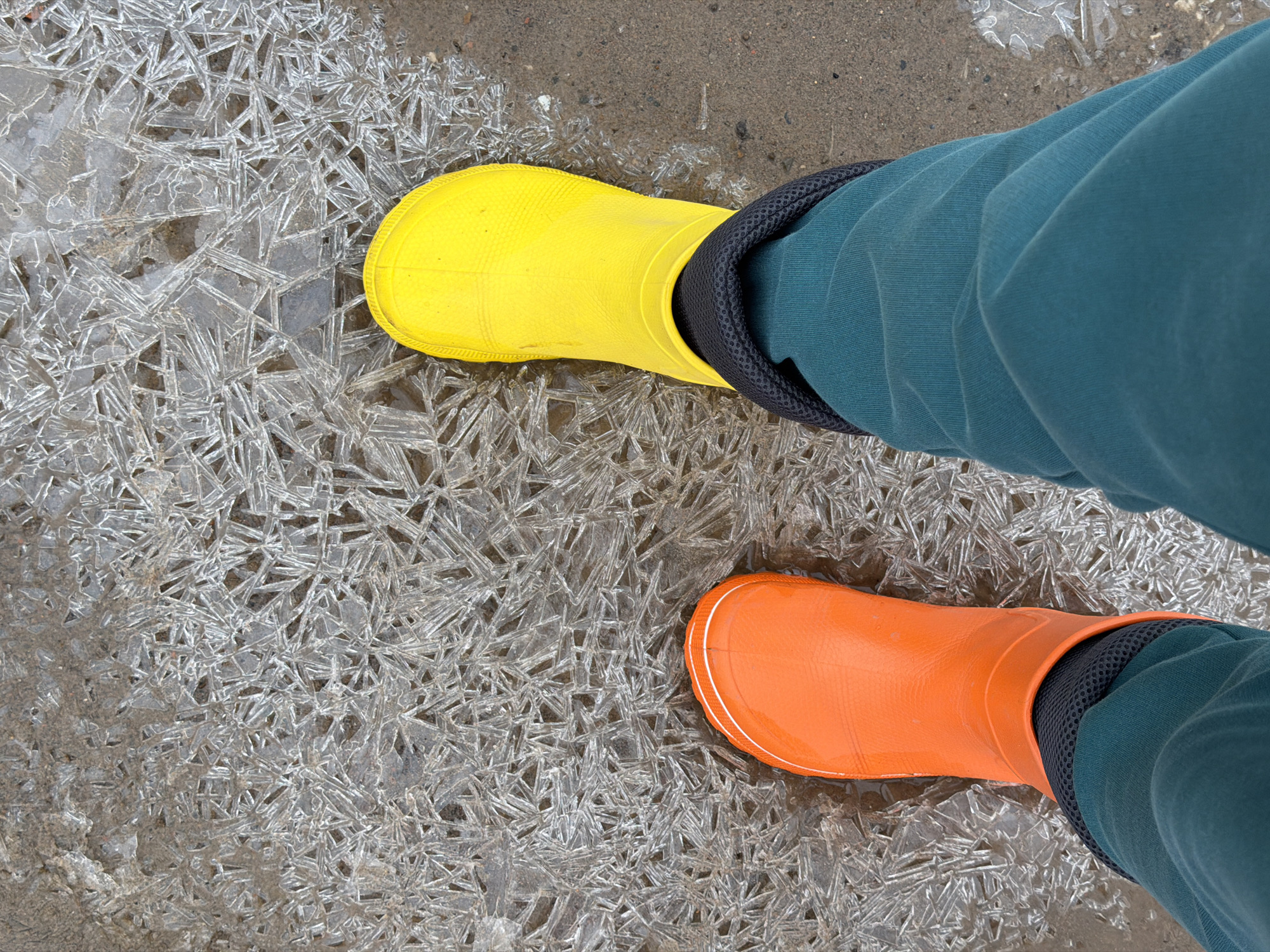 Woman in mismatched boots walks through puddles in Russia