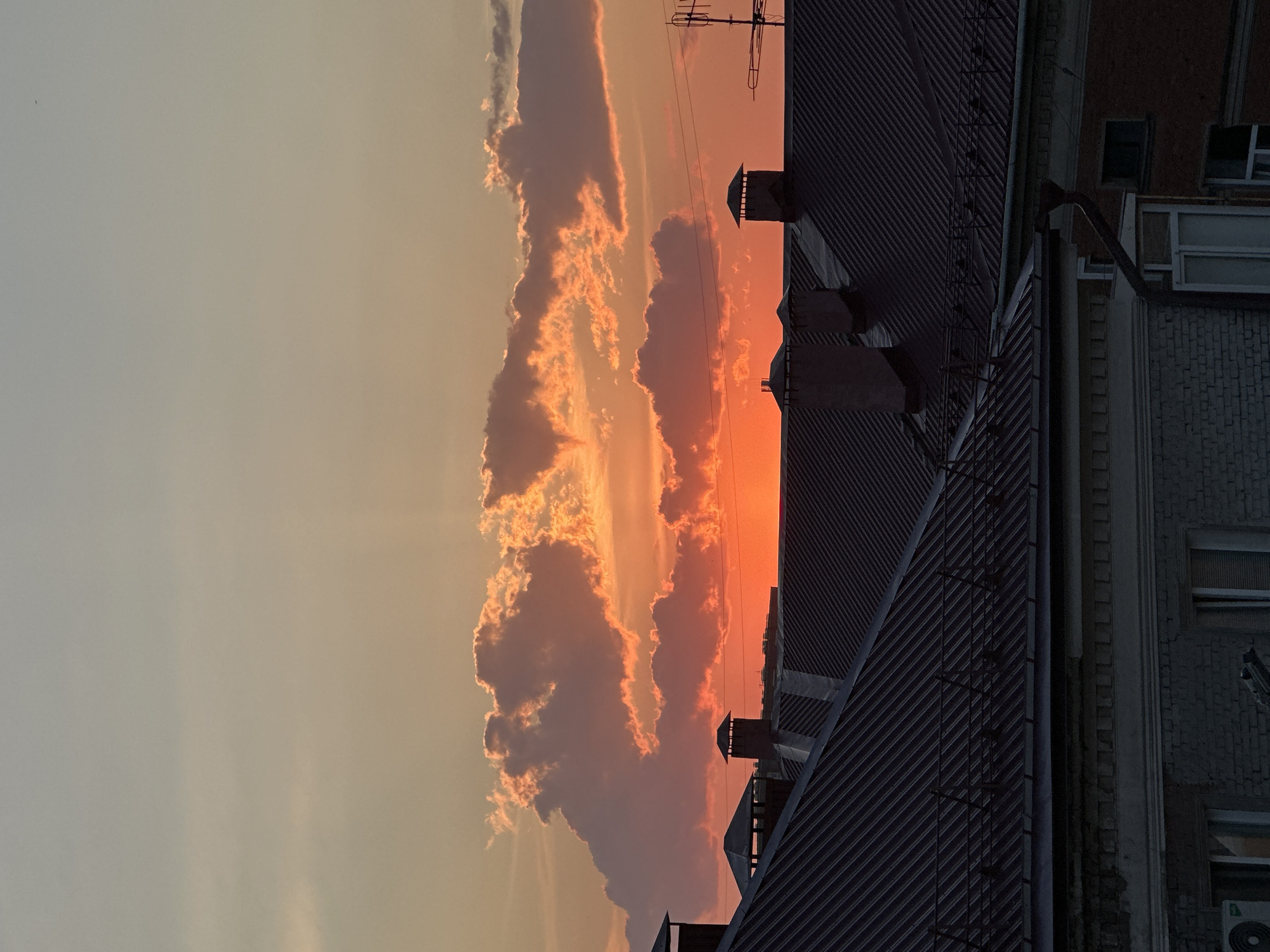 Warm sunset clouds glow over Omsk rooftops