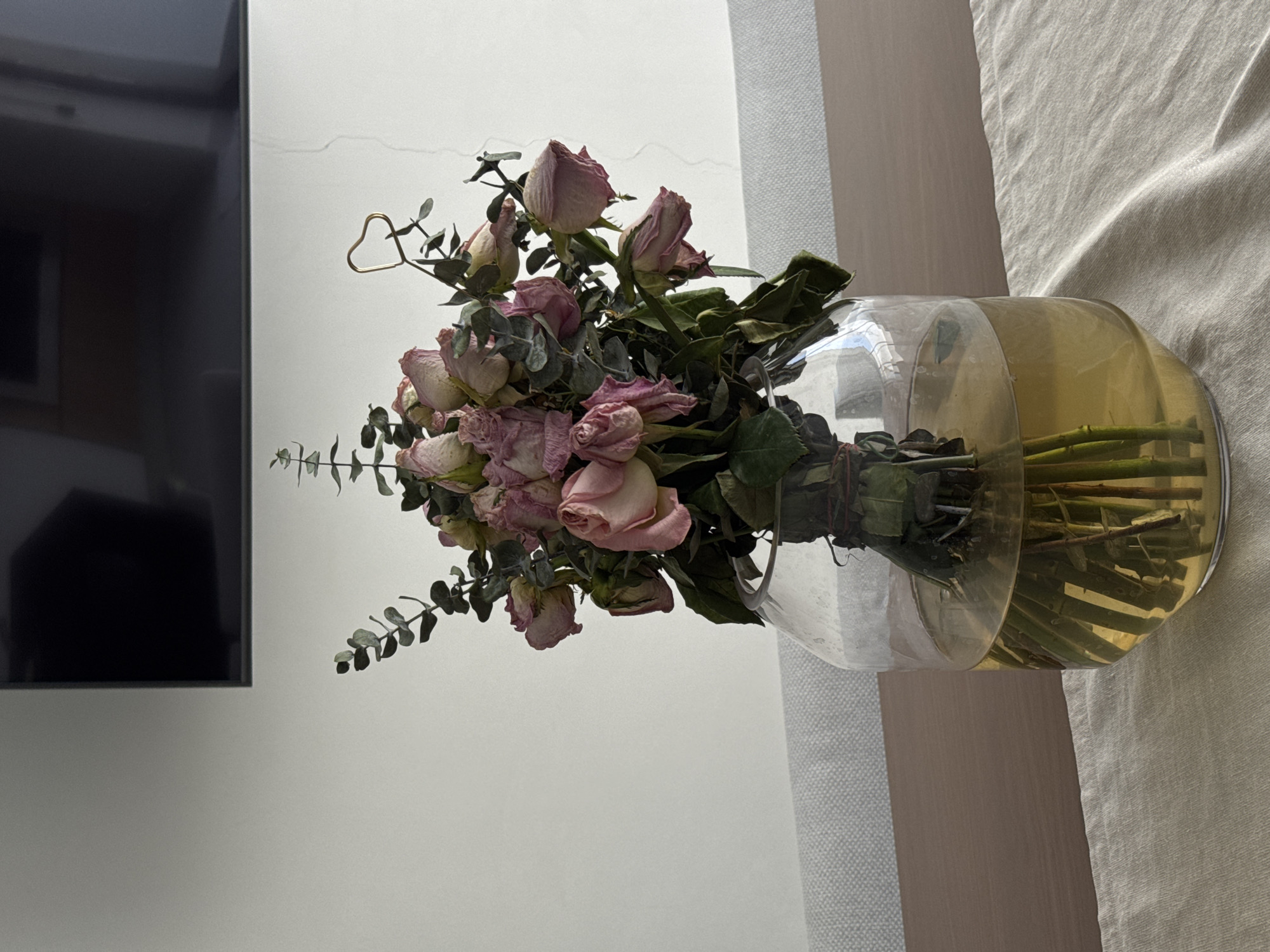 Dried pink roses displayed in glass vase in Puebla