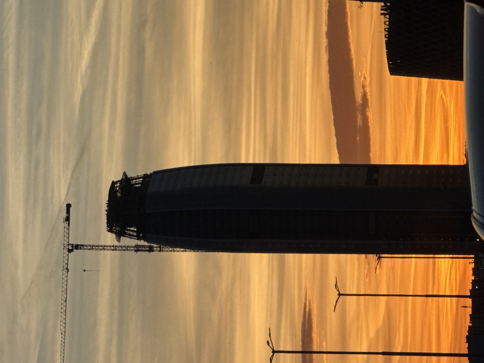 Construction site silhouetted against sunset sky in Sofia