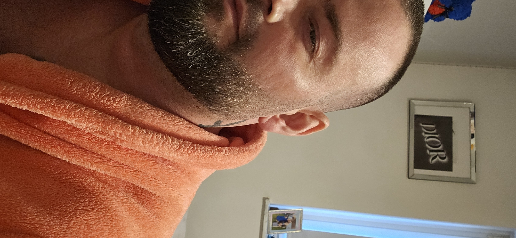 Man with coral towel observed in Gütersloh interior setting