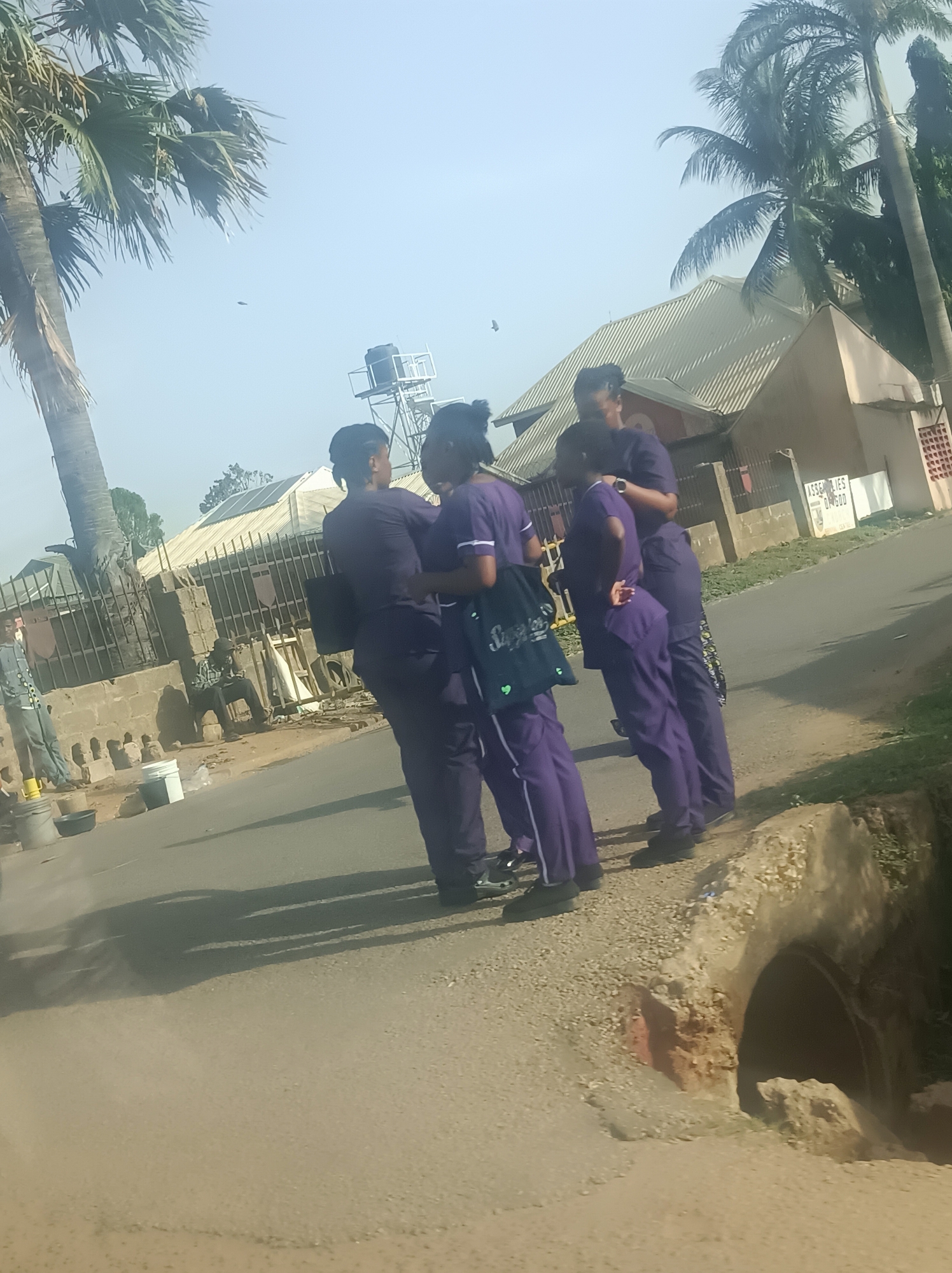 Purple-uniformed group and motorcyclist observed in urban street scene